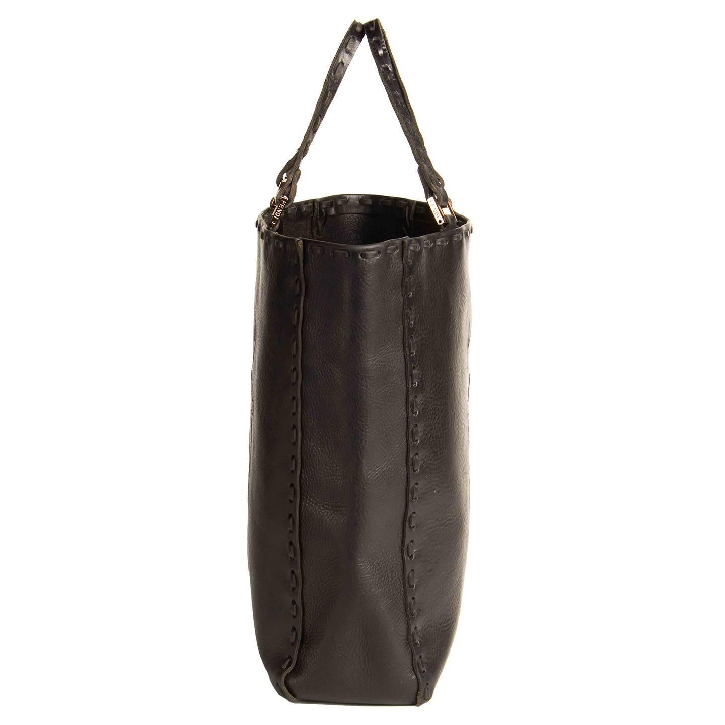 Black leather tote bag with beautiful crowns and antlers embossed design on front and back, while all edges of the bag and handles are enriched by thick leather top stitches. The handles are attached with elegant rectangular copper buckles, while a