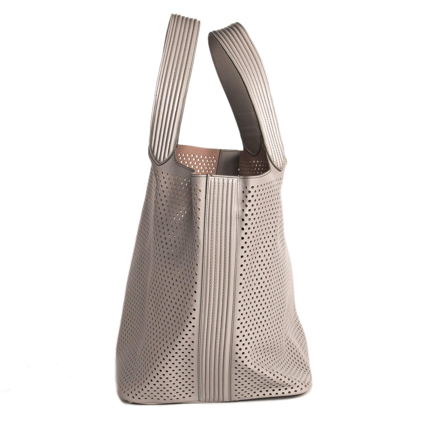 Large perforated light grey leather tote bag with a removable pouch attached inside. The inner leather is tan color to create a very elegant contrast with the outer layer.

Size  H 13" L 22" W 11" Straps 9"

Condition 