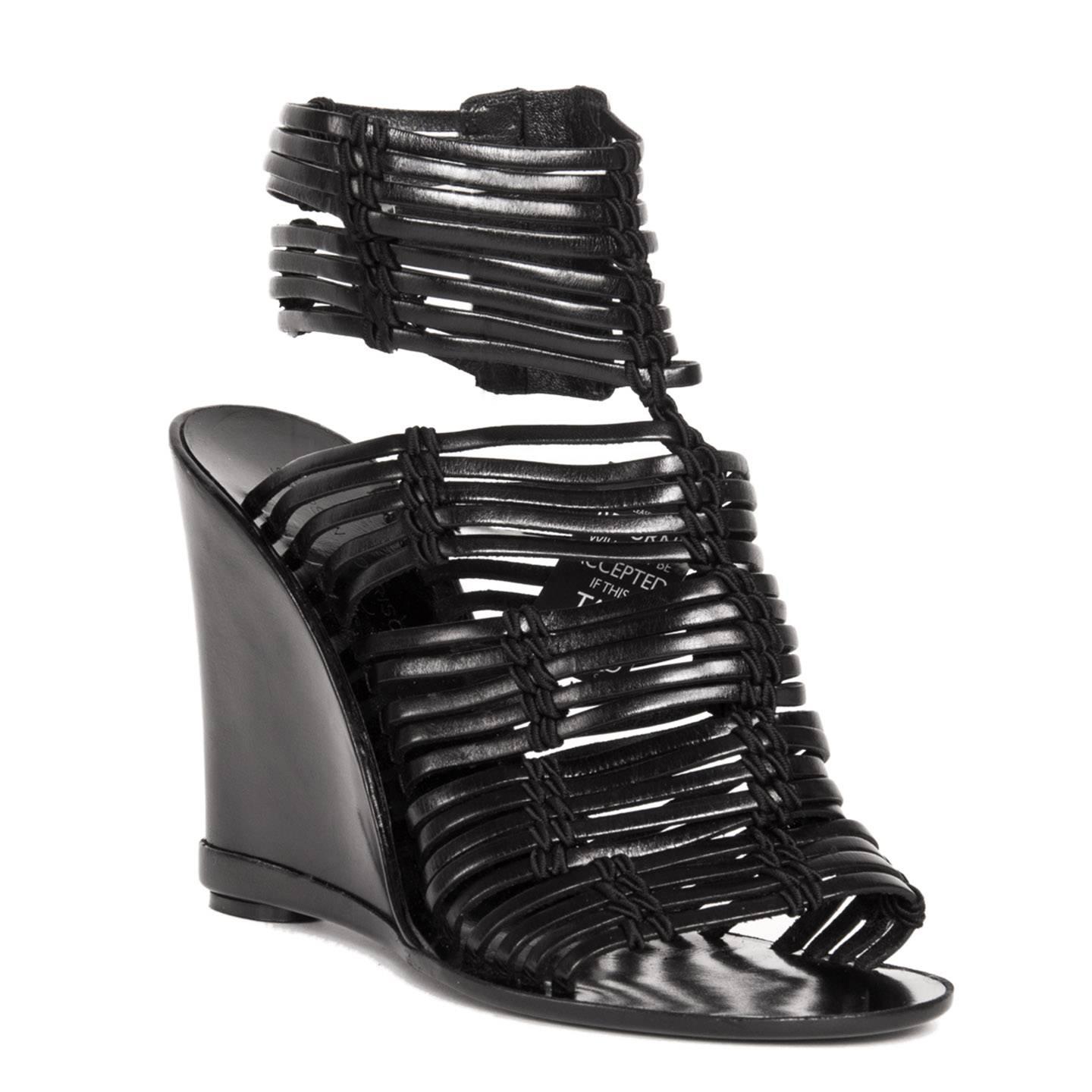 Black leather glove wedges created with thin stripes of black leather hold together to create wider stripes by black laces waved elegantly at front and sides. The ankle strap opens with a instep silver metal zipper. Wedges heel 4.5