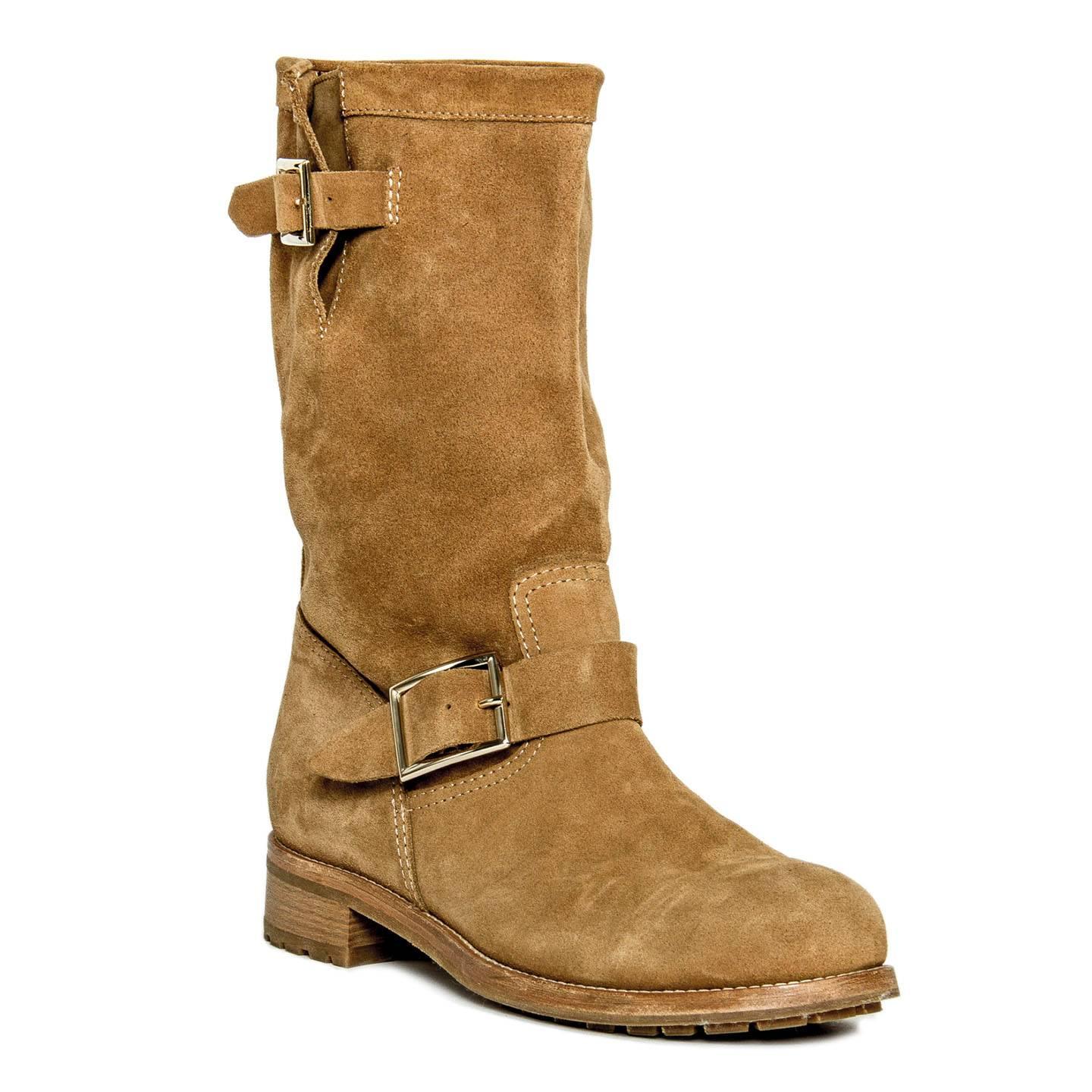 Whiskey brown suede pull on yard calf boots with front band fastening at side ankle with a silver buckle that matches the one on top edge. The whole boots are enriched by stitching details, a silver plaque stamped with the designer name embellishes