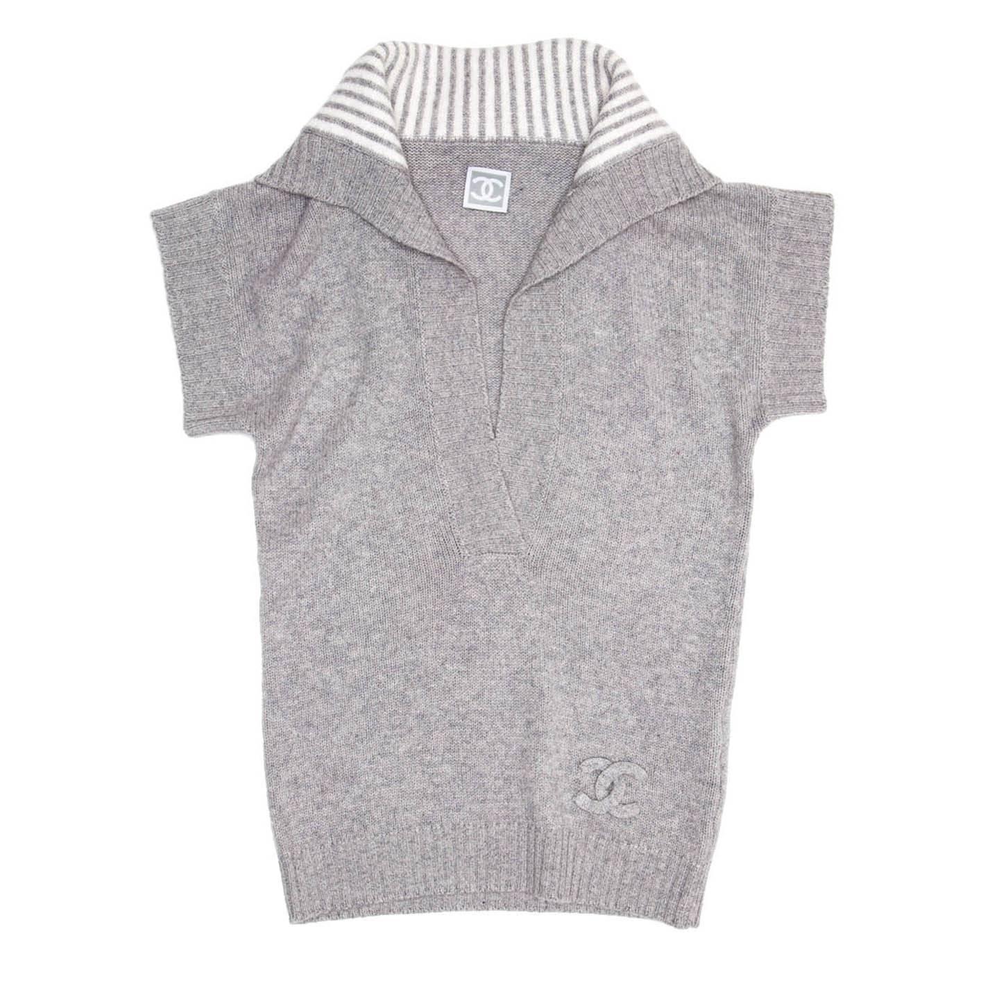 Light grey soft cashmere deep V-neck sleeveless knit with dropped shoulders and ribbed cuffs, neck profile and hem. The neck is very high and it folds on the shoulders creating a sailor collar look, enriched by an ivory and grey striped inner part.