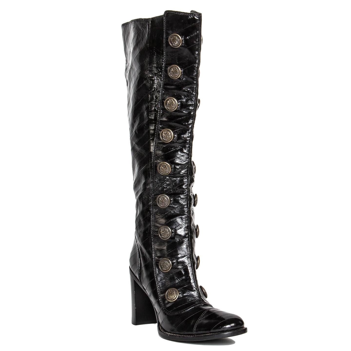 Black eel skin knee high boots with a front patch and two rows of ornate buttons with a vintage military vibe that characterize this style. The eel leather is quite shiny and was applied in stripes, which creates a unique texture, while two patent