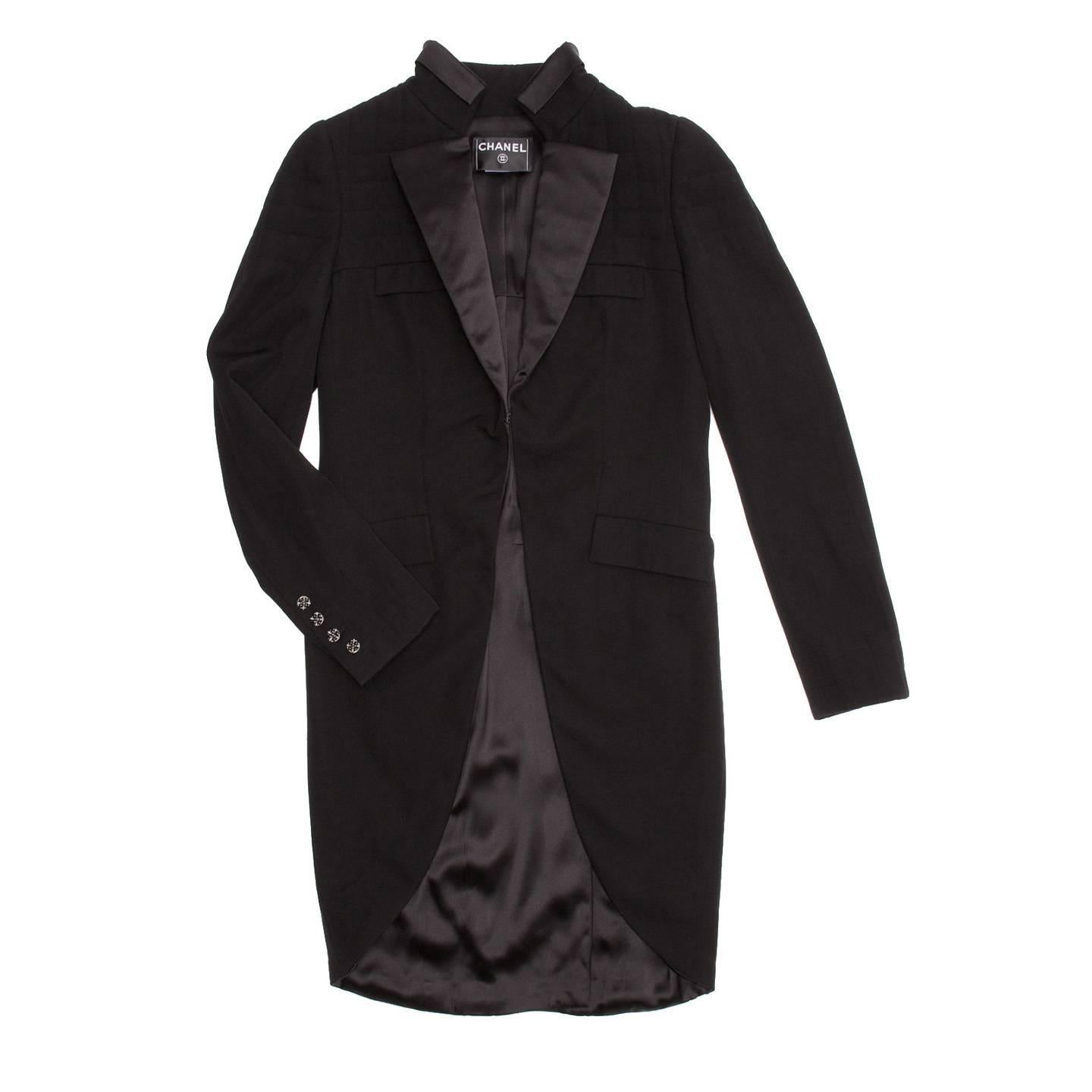 Black tux style wool tailcoat with standing collar decorated by a satin insert to match the satin lapel. The top part of body and sleeves is lightly quilted following the yoke line. Four beautiful silver and black metallic buttons adorn the cuffs