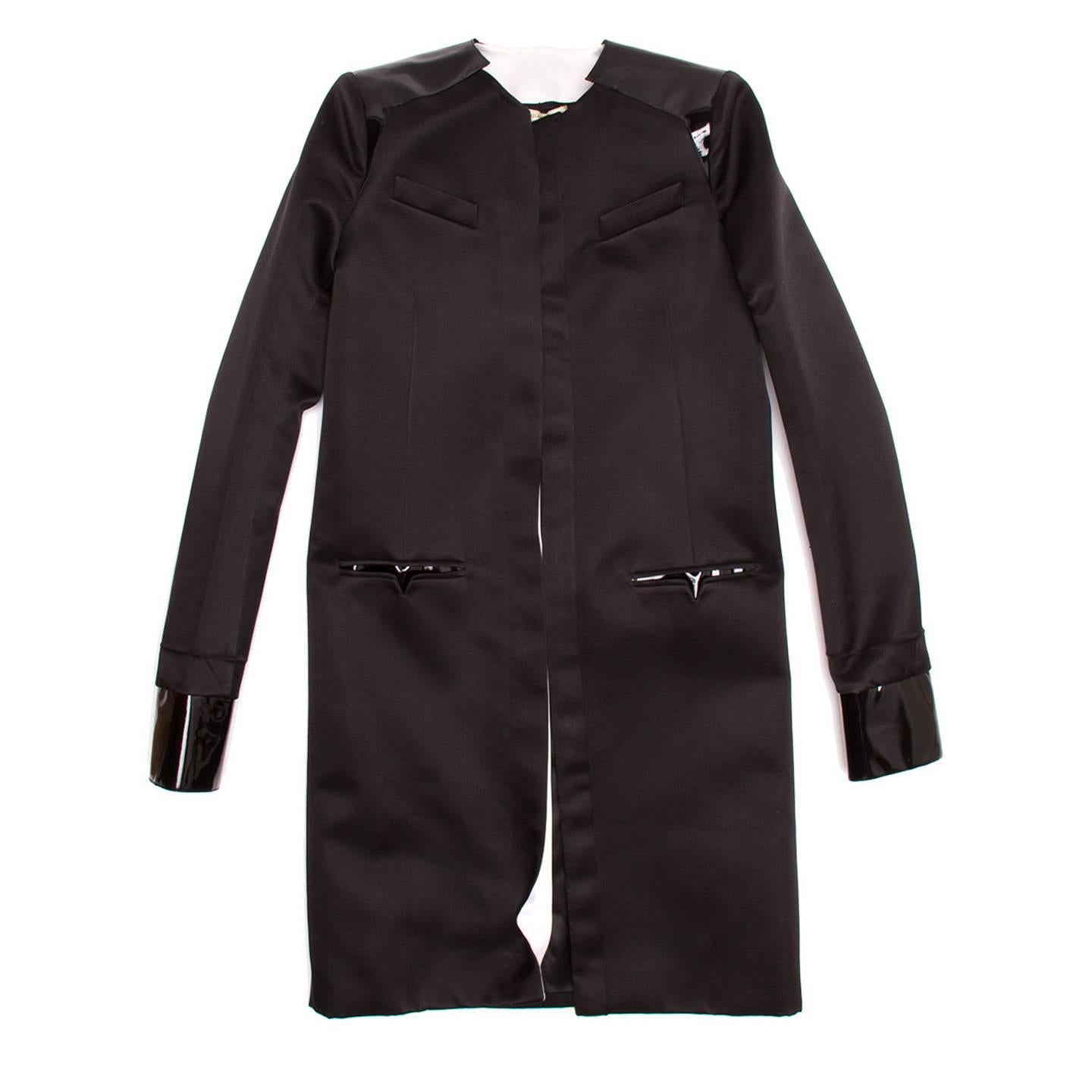 Black silk loose fit overcoat with patent leather detailing on cuffs and shoulders.

Size  42 French sizing

Condition  Excellent: never worn with tags