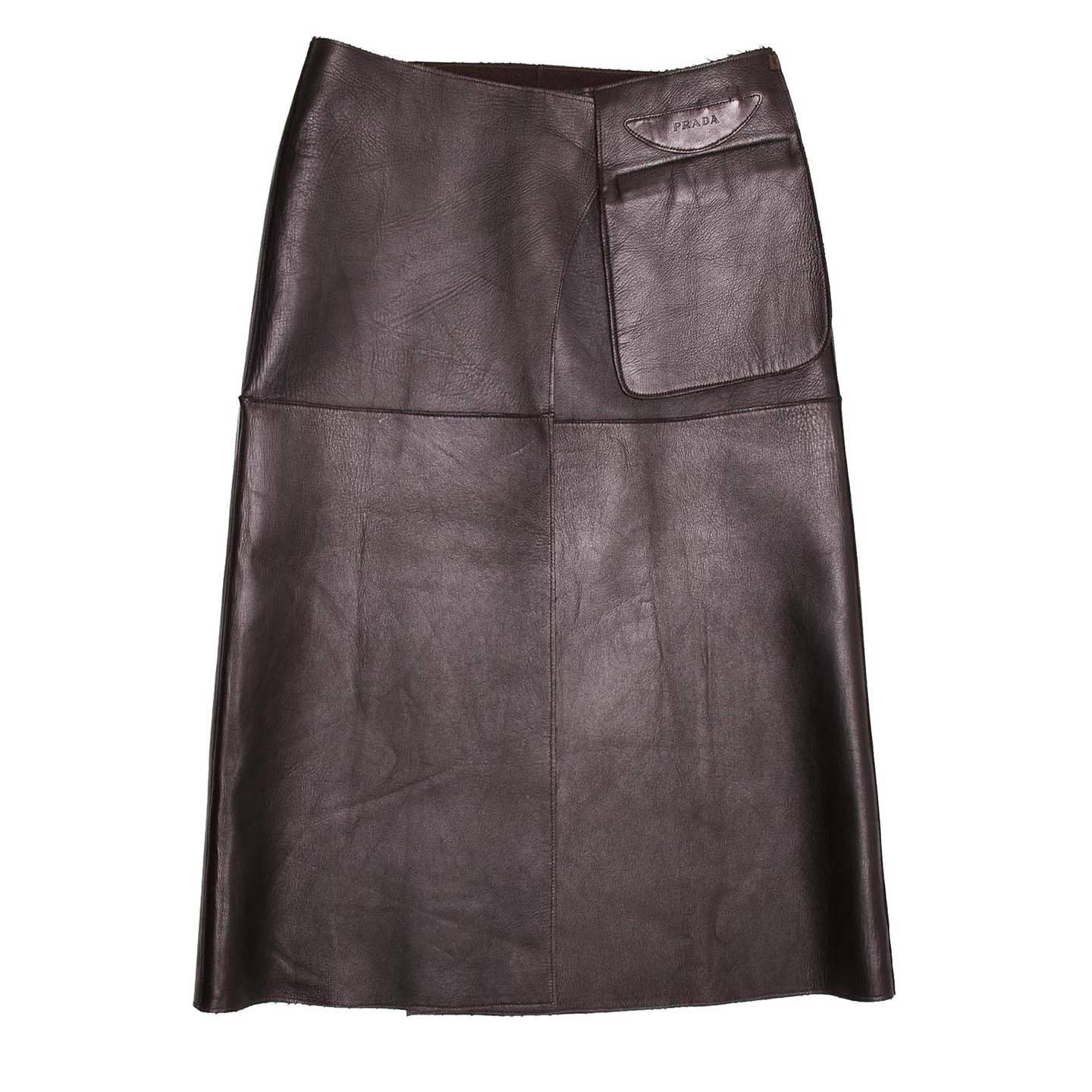 Dark brown leather reversible skirt with chocolate brown camel hair inside. It is a high waisted skirt with a wrap closure and a pouch pocket detail embellished by a Prada logo on the leather side.

Size  44 Italian sizing

Condition  Excellent: