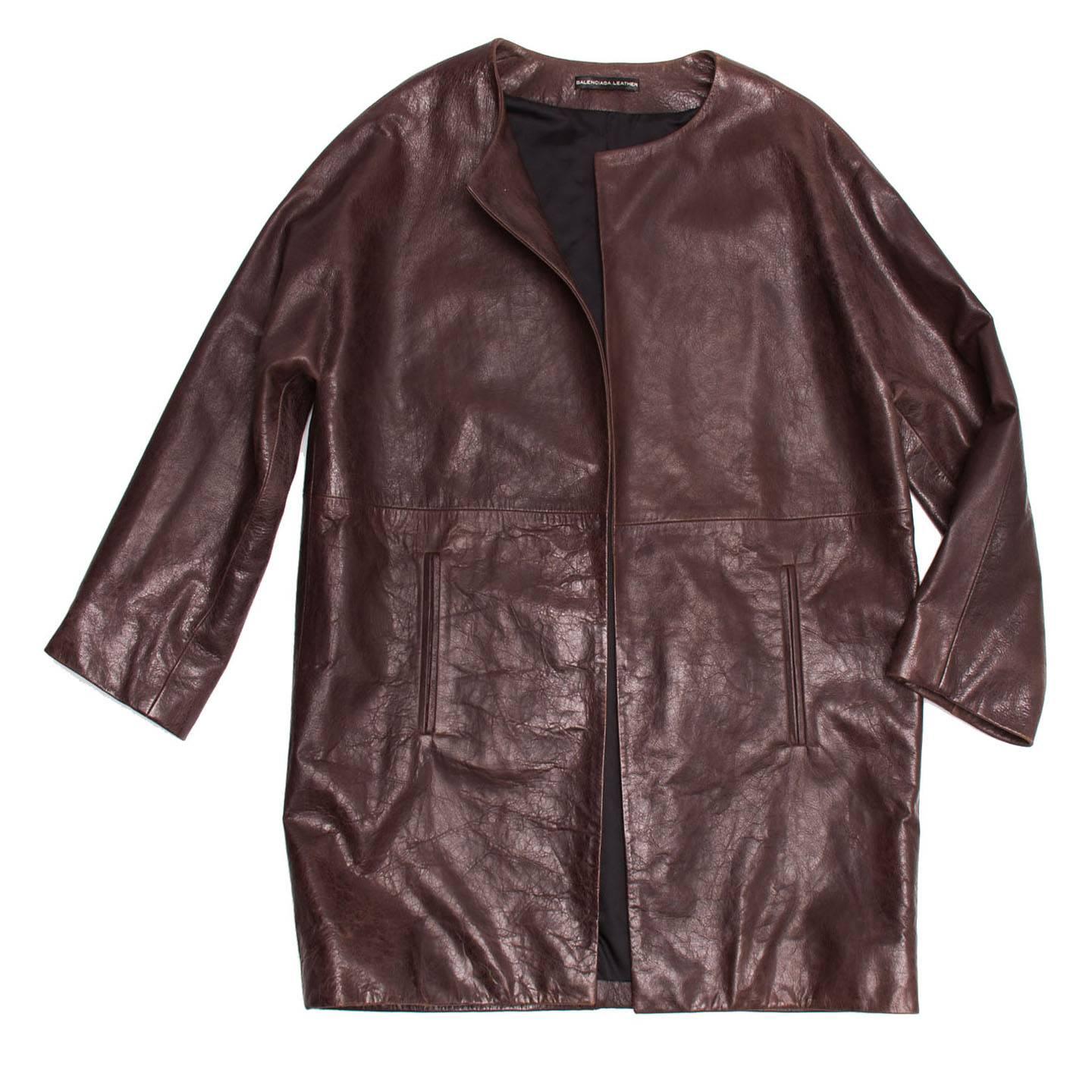 Burgundy lambskin leather coat with round collar and dolman sleeves. The fit is boxy and mid-length; the front is open and buttonless and enriched by two vertical welt pockets at lower waist. Made in France.

Size  42 French sizing

Condition 
