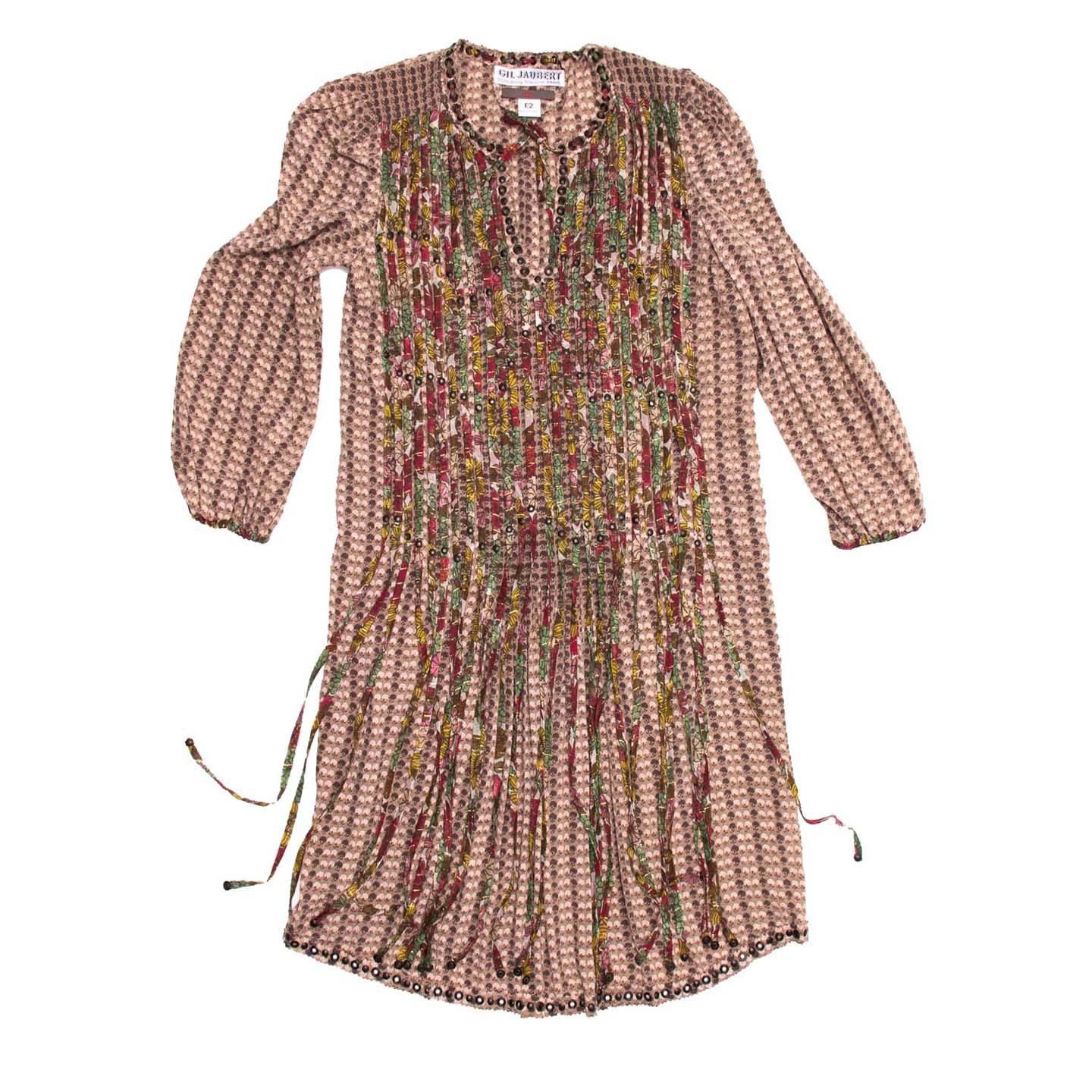 Lovely Bohemian style dress in a small floral printed silk. Long sleeves with gathered cap sleeves and elasticized printed binding at cuffs. Small nailheads around neckline, front, and bottom hem. Contrast printed vertical strips from yoke area
