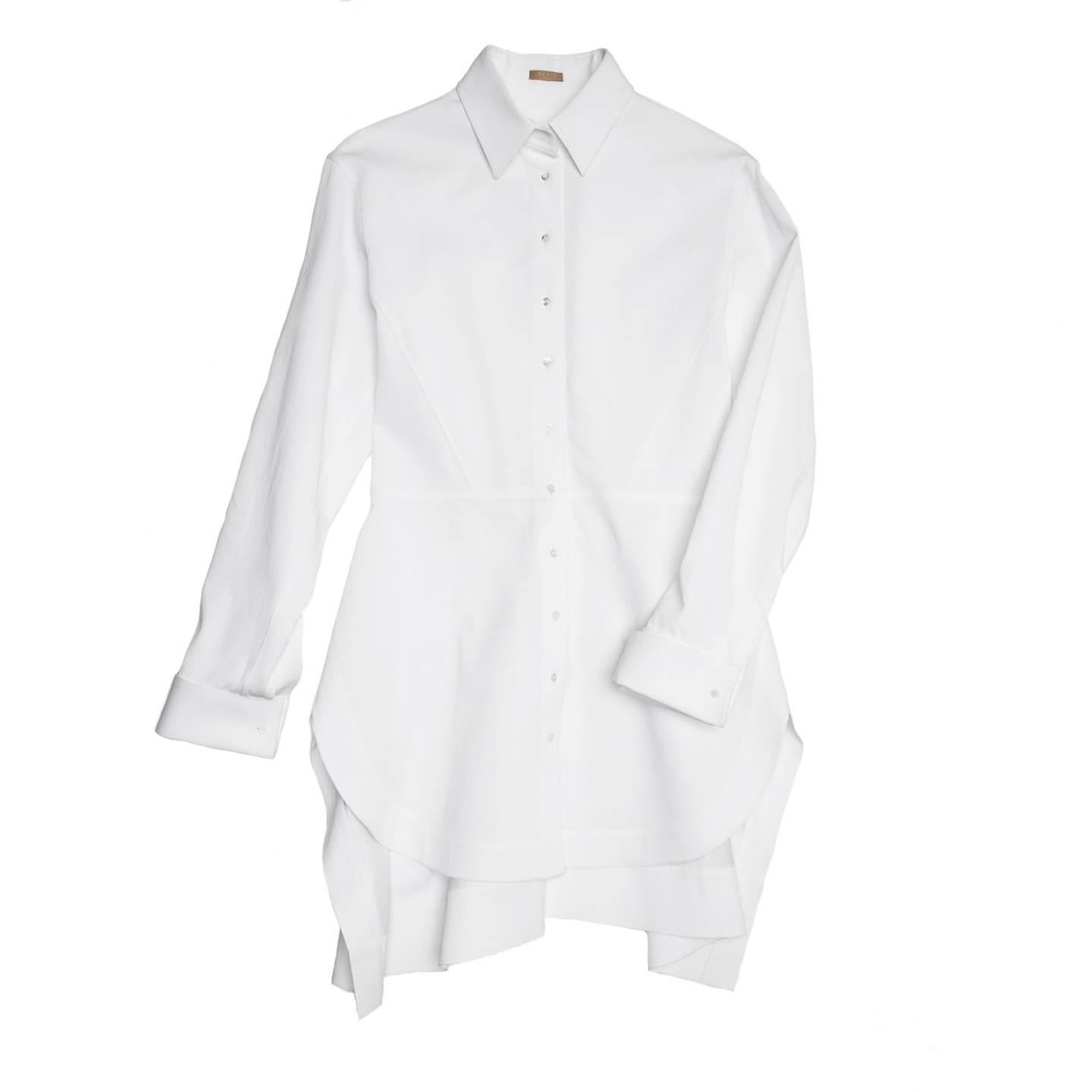 White thick cotton twill long shirt with peter pan collar, peplum waist seam at front and belt insert at back. The skirt part is flared and both the back body and skirt are ruched. The front hem is round while the back is squared; the cuffs are