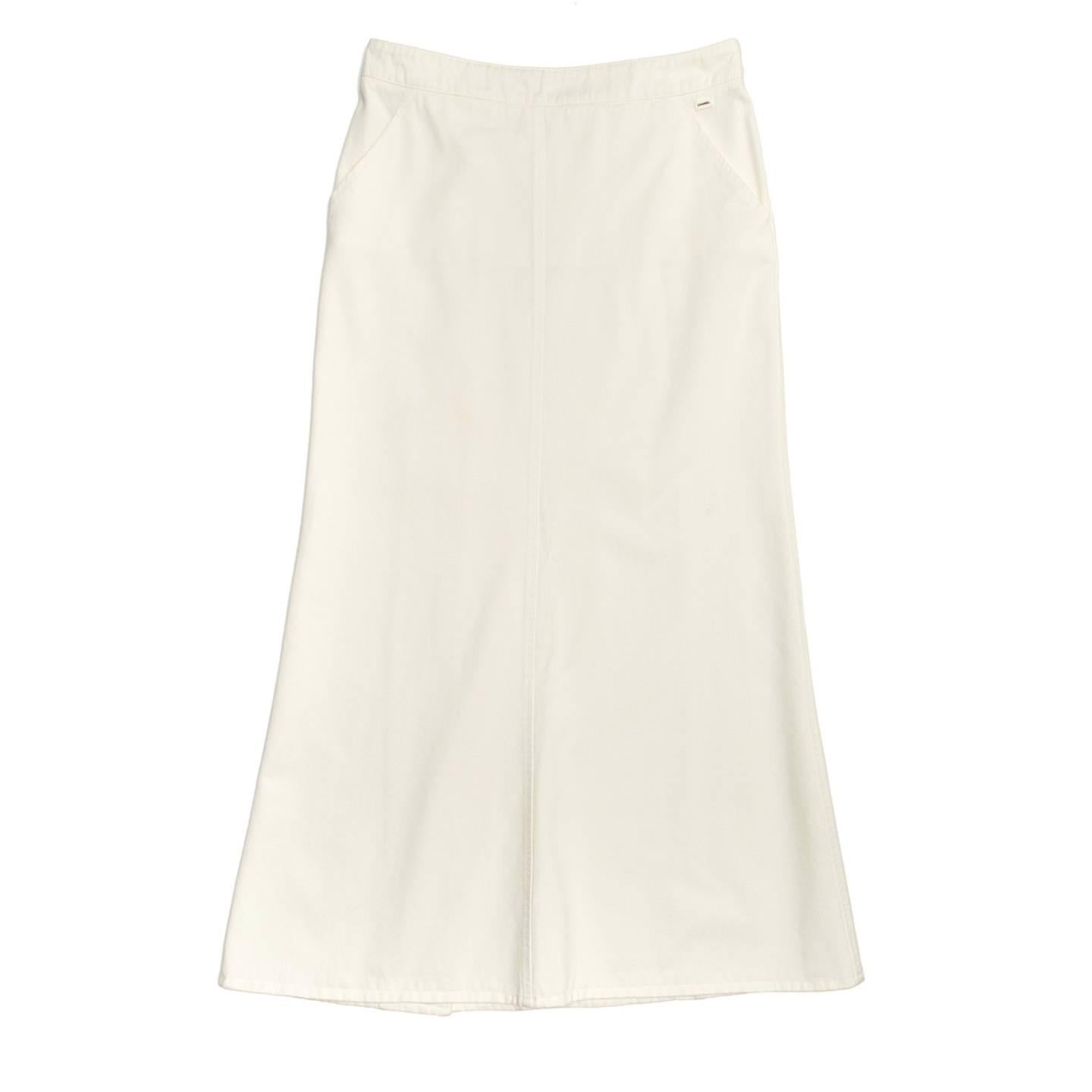 White denim long skirt with slash pockets at front and an off centered back opening that creates a slit. The back is enriched by big round self-fabric buttons with metal eyelets.

Size  44 French sizing

Condition  Excellent