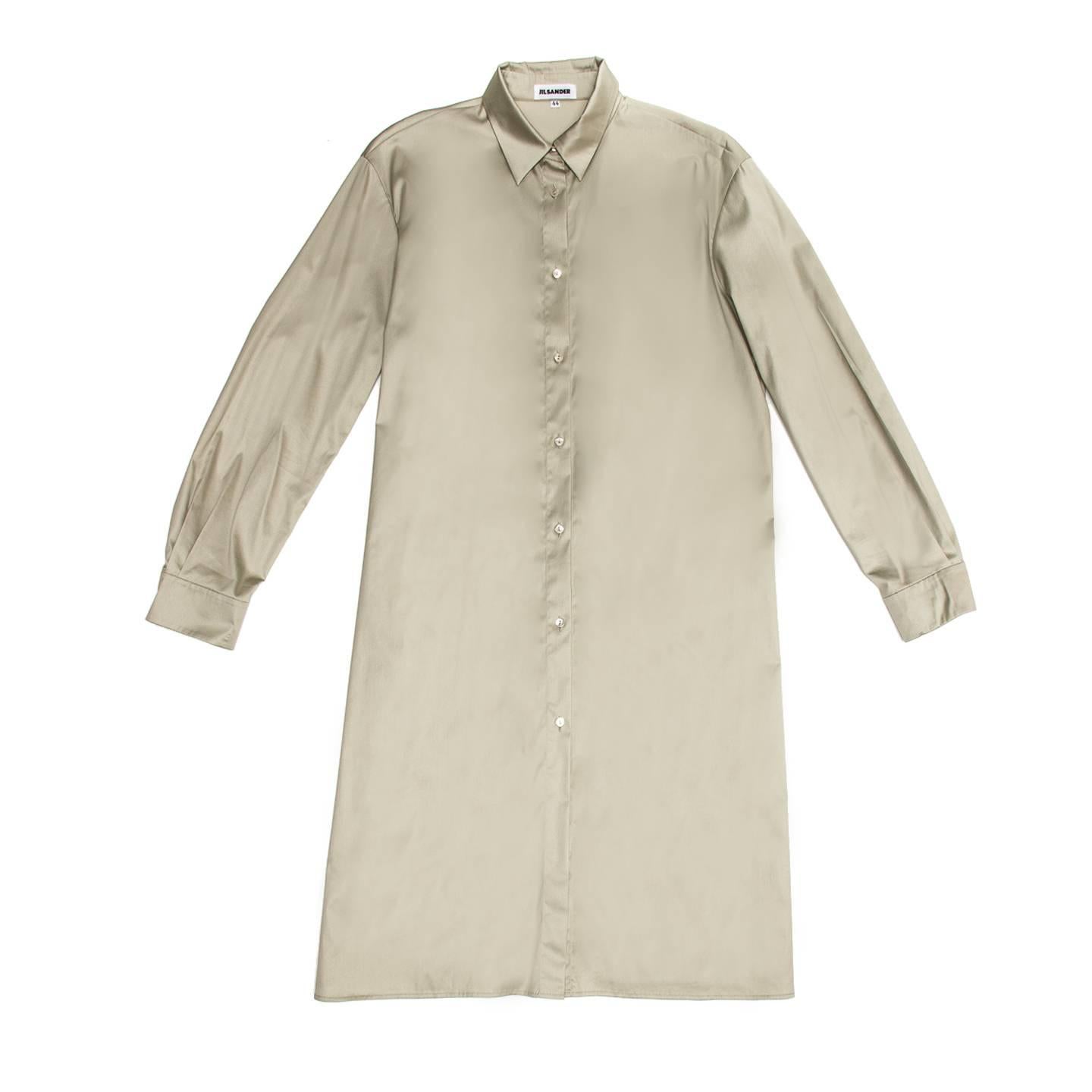 Khaki cotton blend shirt dress with straight fit and below knee length. The shirt collar is peter pan style, the front opens from neck to hem and is enriched by little mother-of-pearl buttons. The sleeves are long with shirt cuffs and pleats while a
