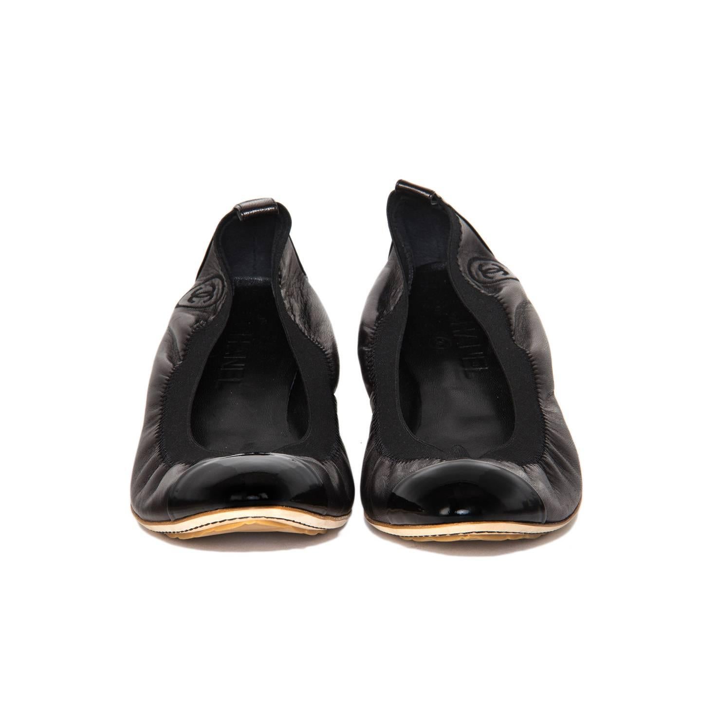 Black leather scrunch ballet flats with patent leather cap toe and heel. A ribbed elastic on top edge is attached to the leather with decorative zigzag stitching and CC Logo. Made in Italy.

Size  41 Italian sizing

Condition  Excellent: never worn