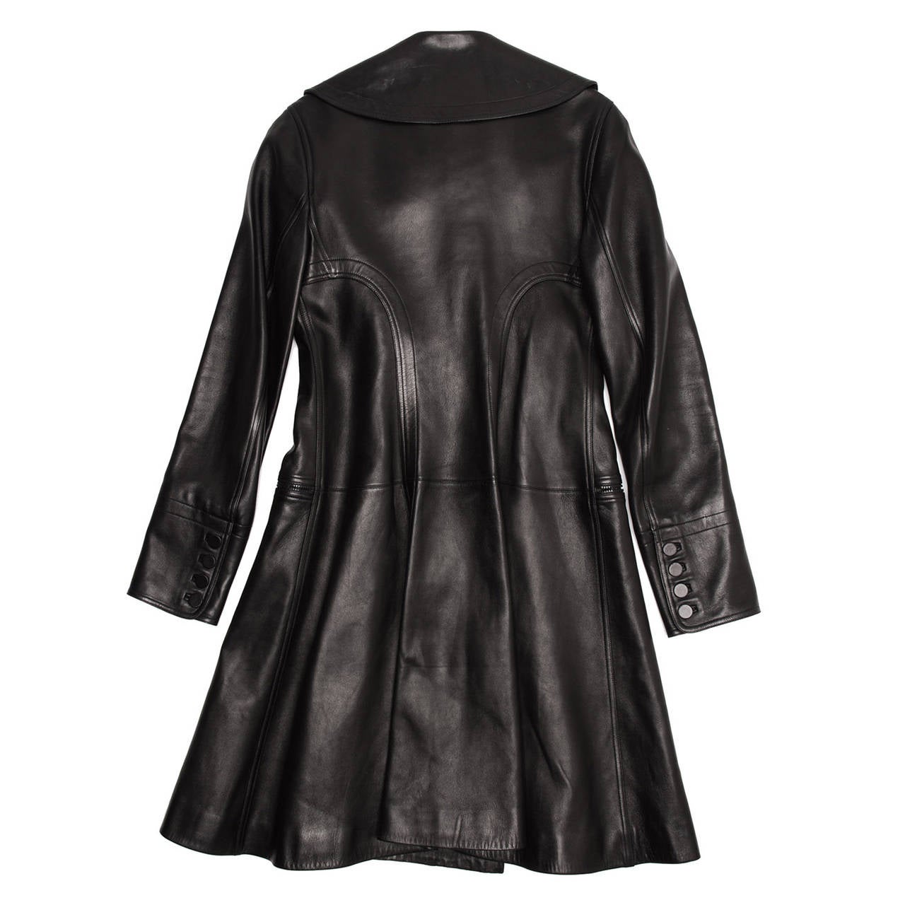 Black lambskin leather trench coat with fitted top and flared skirt. The lapel is quite wide with rounded edges, the six buttons at front are beautifully leather covered and two zipper pockets sit horizontal on the waist line. The cuffs are adorned