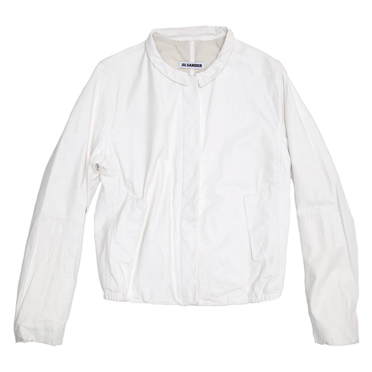 Beautiful soft white leather bomber style jacket with a small peter pan collar. The front fastens with caramel color buttons concealed under a leather flap. The side pockets also fasten with matching buttons concealed under flaps.

Size  40 French