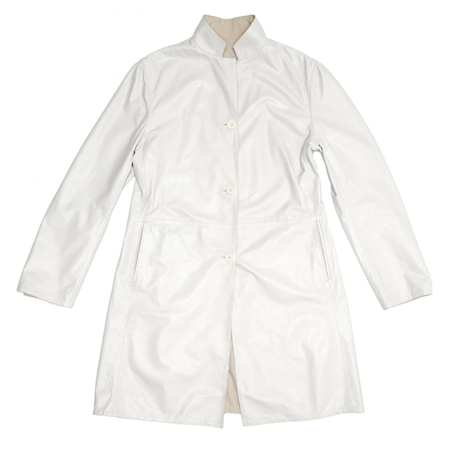 Reversible white leather coat with tan lining. This style is reversible, with tone-on-tone buttons to match the fabric, elegant slash pockets on the leather side and more casual zipped vertical pockets on the tan color side. The small notched collar