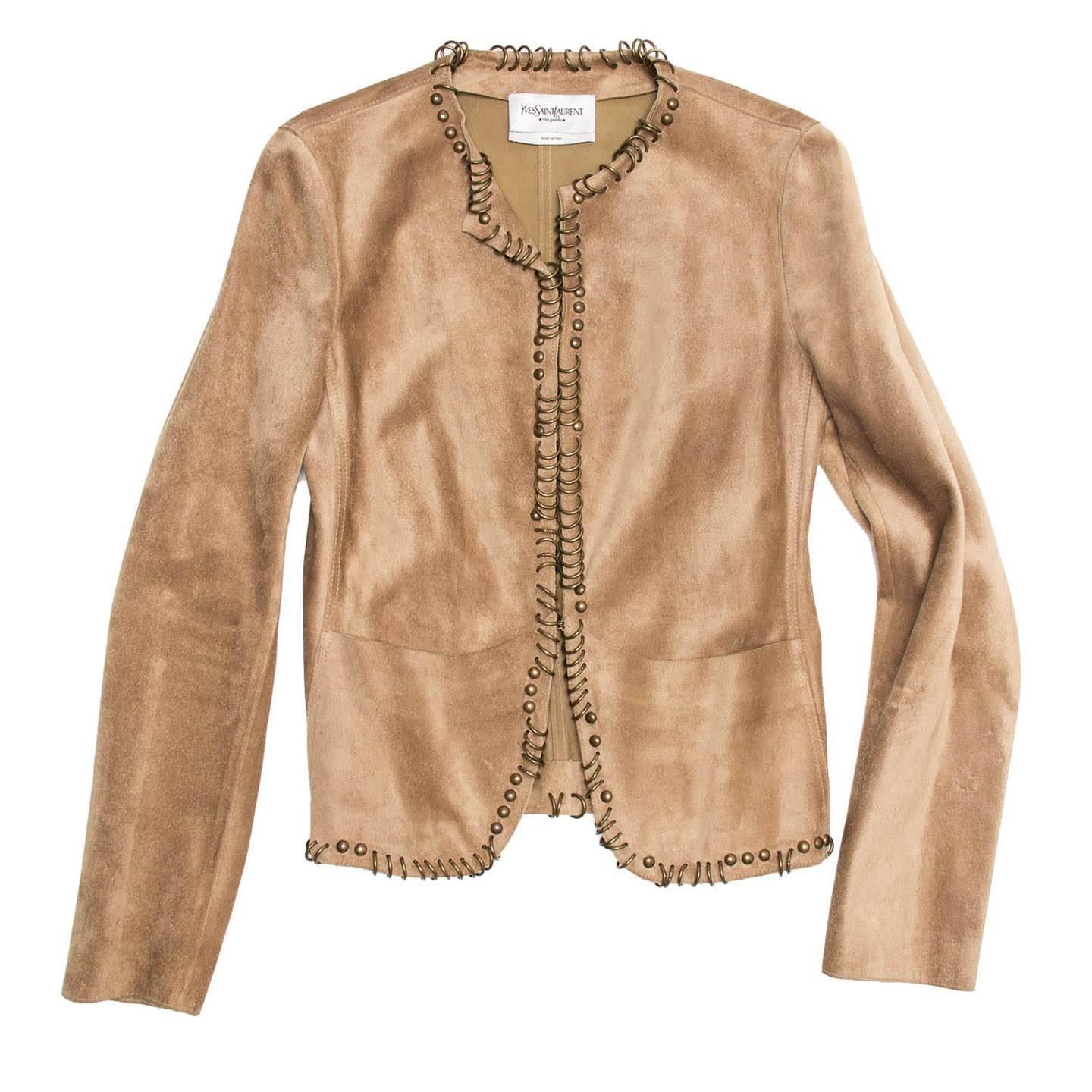 Tan suede jacket with 2 patch pockets at front. Brass metal rings and studs along center front, neckline, and hem. Hook and eye closure. Tonal topstitching.

Size  42 French sizing

Condition  Excellent: worn a few times