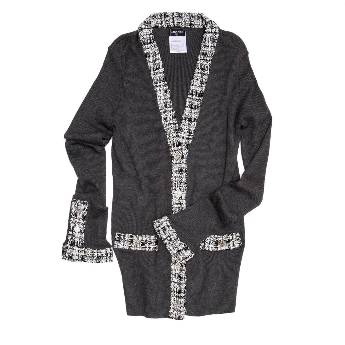 Grey cotton ribbed knit cardigan with black & white tweed inserts at V-neck, button flaps, cuffs and pocket. The cuffs have a shirt opening detail with 3 Chanel logo metal buttons to match the ones at center front and pockets. The fit is quite