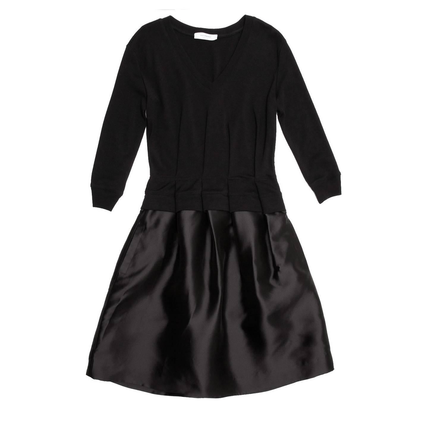 Black flare cocktail dress with fleece top and soft taffeta skirt. At waist the top is folded and stitched together with the skirt creating a soft volume with deep pleats. The neck has a moderately deep V-shape and the sleeves are 3/4