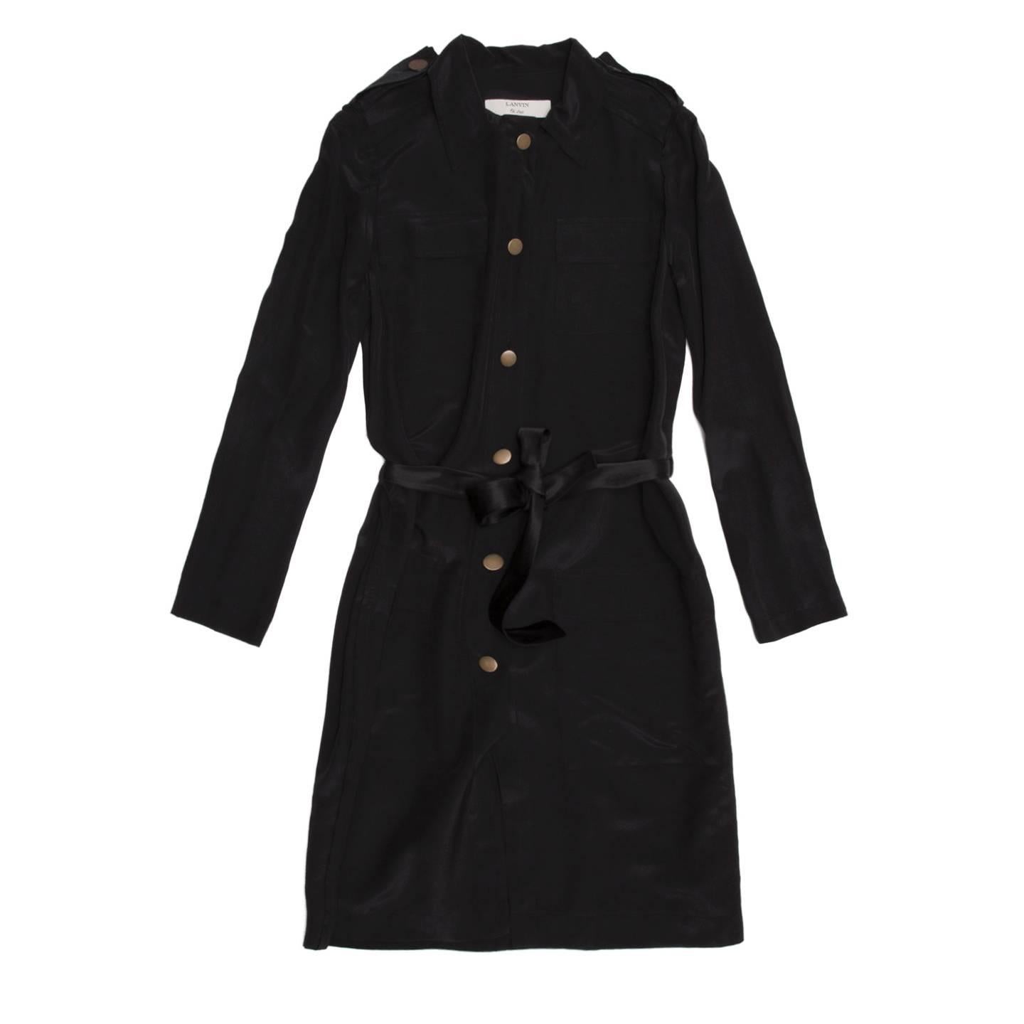 Black silk/cotton blend shirt-dress whit a spread shirt collar and brass metal buttons fastening the front opening from neck to hem. The front is embellished by 4 squared patch pockets with flaps and the waist by a satin belt to knot at front. The