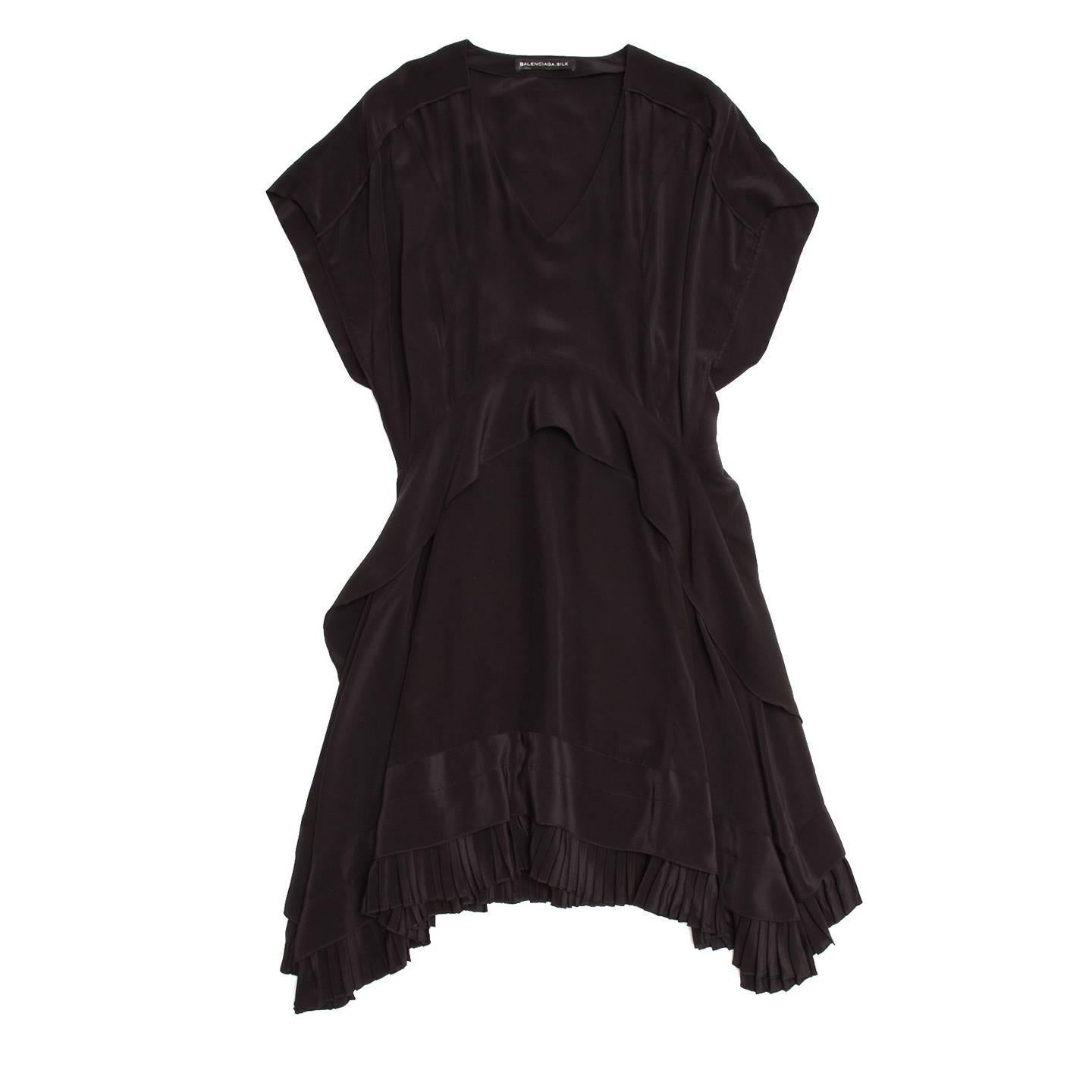 Stunning black silk bias cut dress. V-neck front and small dolman sleeves. Curved tiers create a lovely cascading detail with pleated hem.

Size  42 French sizing

Condition  Excellent: never worn