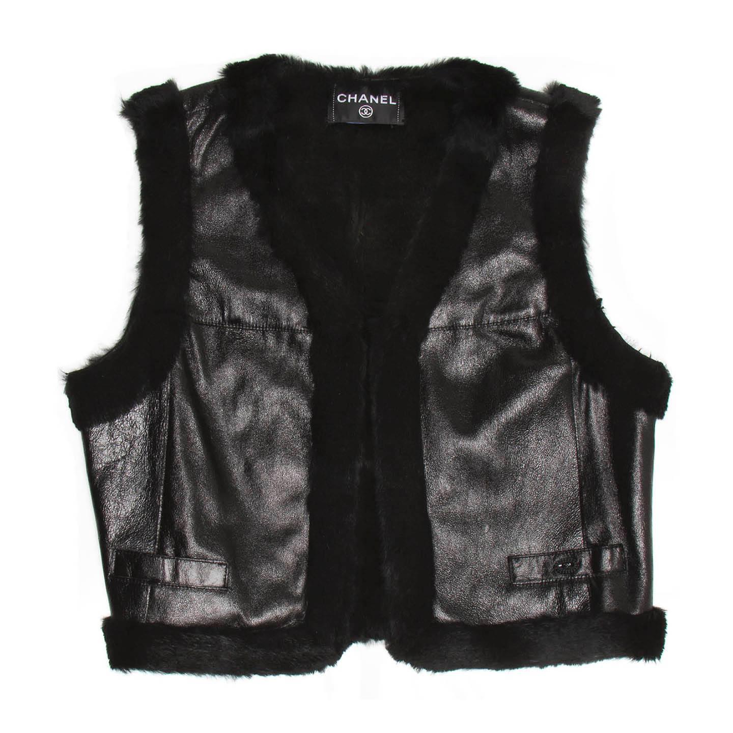 Black leather cropped open vest with rabbit fur lining and profiles around armholes, neck, front opening and hem. The leather is quite shiny and the front is enriched by two small slash pockets and a little black Chanel logo placket. Made in