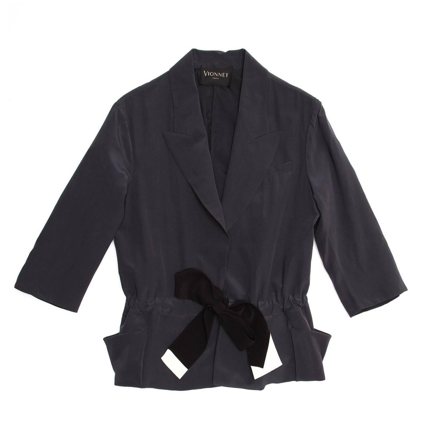 Elegant dark grey silk crepe jacket with 3/4 sleeves and a black and ivory ribbon drawstring that accentuates the waist. The black silk belt is visible at back, while is concealed at front where it gathers the body fabric creating volume and fastens