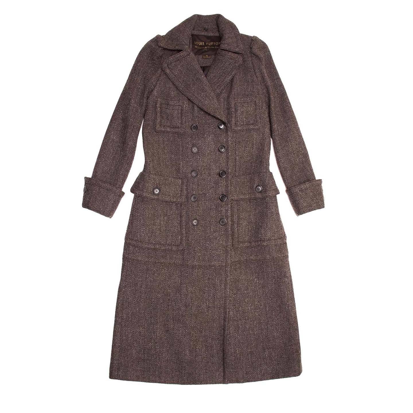 Long double breasted grey/brown coat with silver threads waved in the wool tweed fabric. The lower patch pockets are big and close with flaps and round buttons, while two small square patch pockets embellish the top part. The cuffs have wide