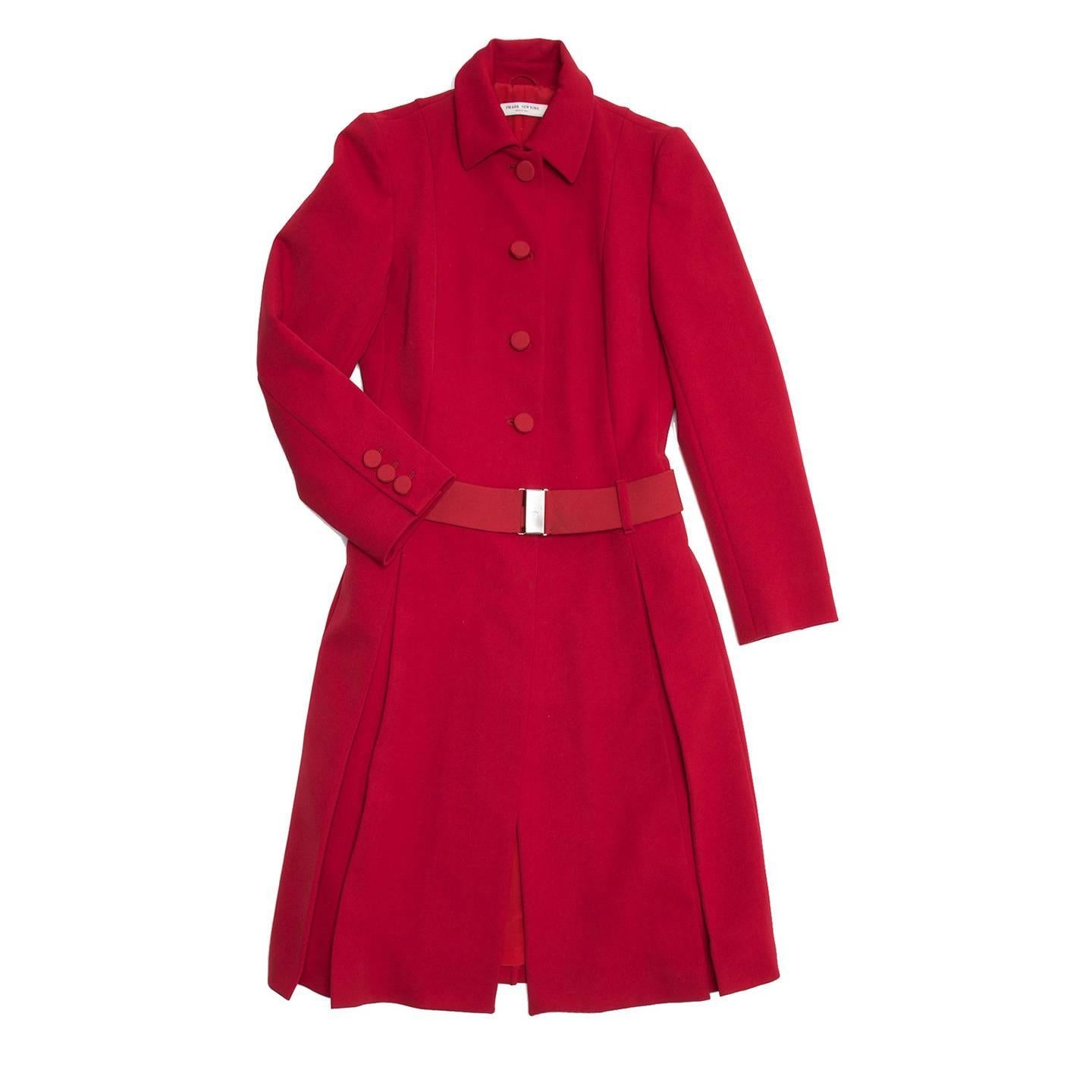 Red quilted lining classic princess cut tailored coat with belted waist, self fabric button closure, and peter pan collar. Prada New York label. Special Edition made for the opening of Prada, Soho, NY 2001.

Size  44 Italian sizing

Condition 