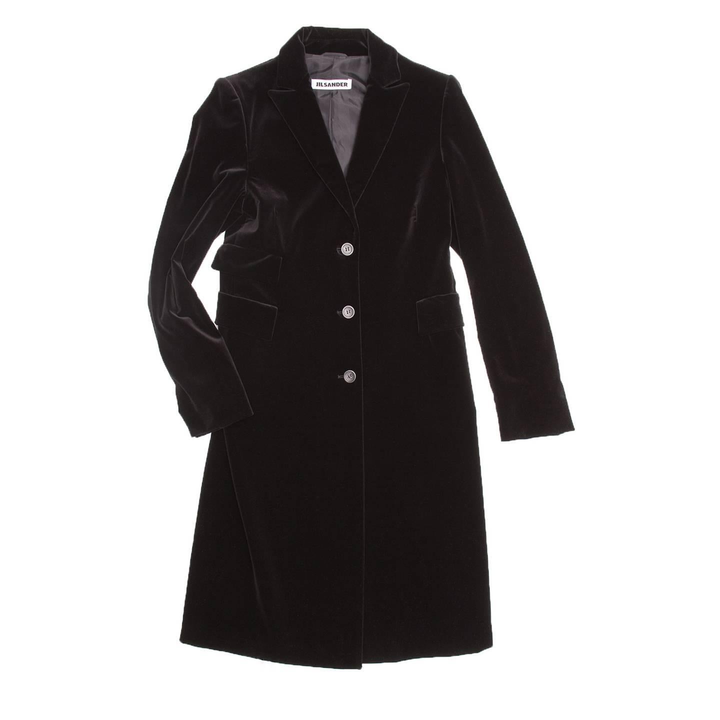 Black cotton velvet knee length coat. Small peaked lapel, three front pockets with squared elegant flaps. Single breasted closure with three buttons. Long back vent starting at hips.

Size  40 French sizing

Condition  Excellent: never worn