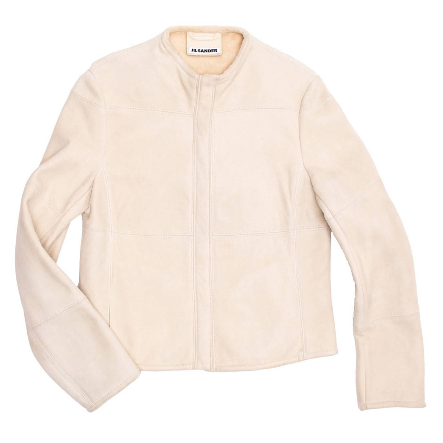 Cream shearling collarless racer style jacket with  tone-one tone hidden zipper at center front.

Size  40 French sizing

Condition  Excellent: worn a few times