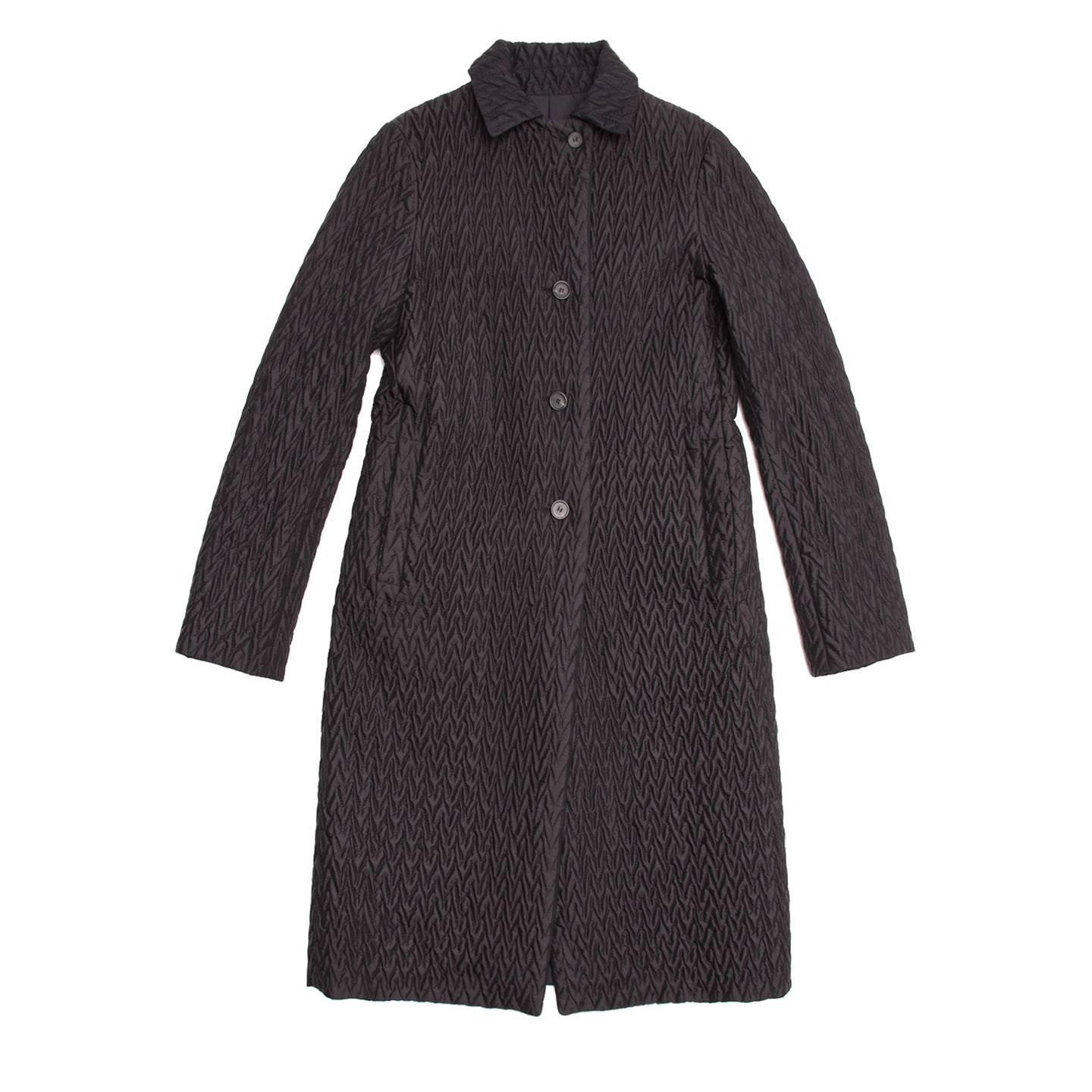 Long black herringbone quilted coat that reverses to a smooth slick nylon side. 4 buttoned closure with 2 single welt pockets at front.

Size  38 French sizing

Condition  Excellent: worn a few times
