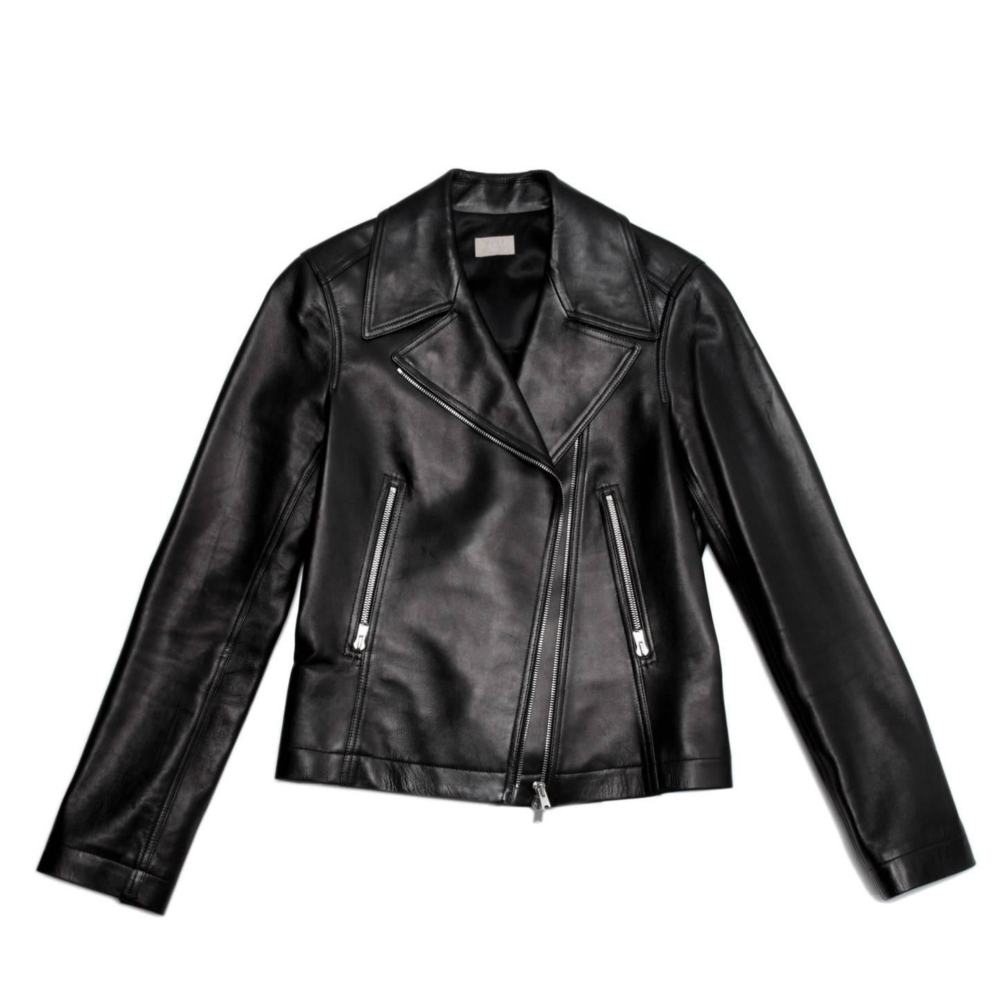 Black lambskin leather motorcycle style jacket with silver metal zipper front pockets that mach the center front zipper and those at cuffs. The back darts form closed vents at bust, they are fixed at waist and then open at hem as inverted pleats. A