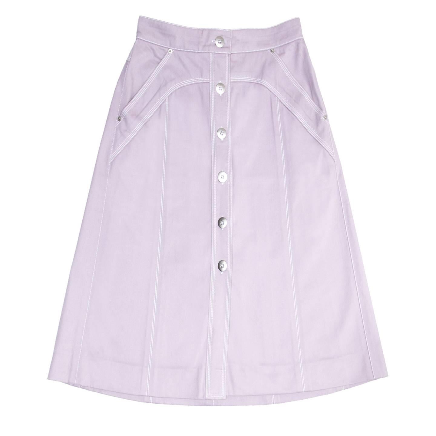 Lavender color moleskin cotton skirt with a buttoned front from waist to hem that leaves a vent from below knees down. The fit is A-shape with high waist and below knee length. The front is buttoned up with large brushed silver metal buttons while