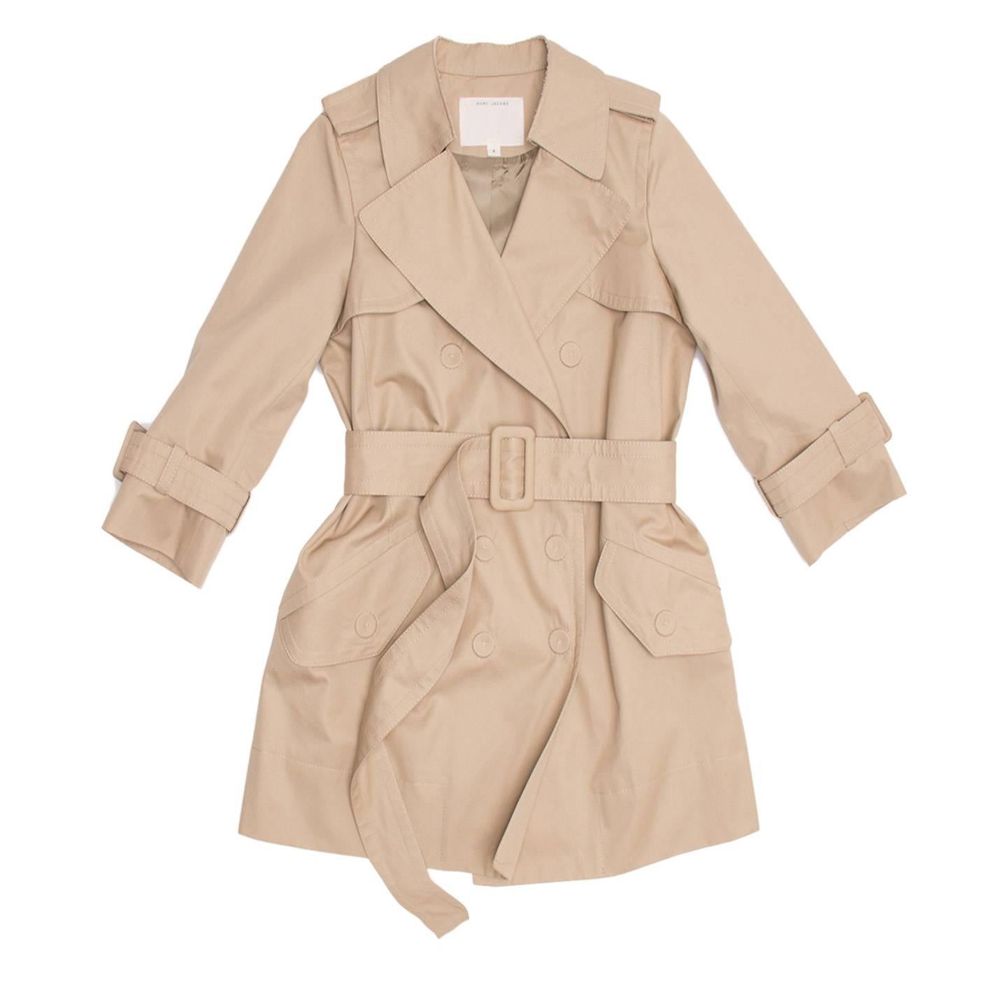 Middle length khaki thick cotton trench coat with 3/4 length sleeves. Double breasted closure with large snap buttons highlighted on the outer layer with beautiful thick tone-on-tone hand stitches and elegantly covered with fabric in the inner