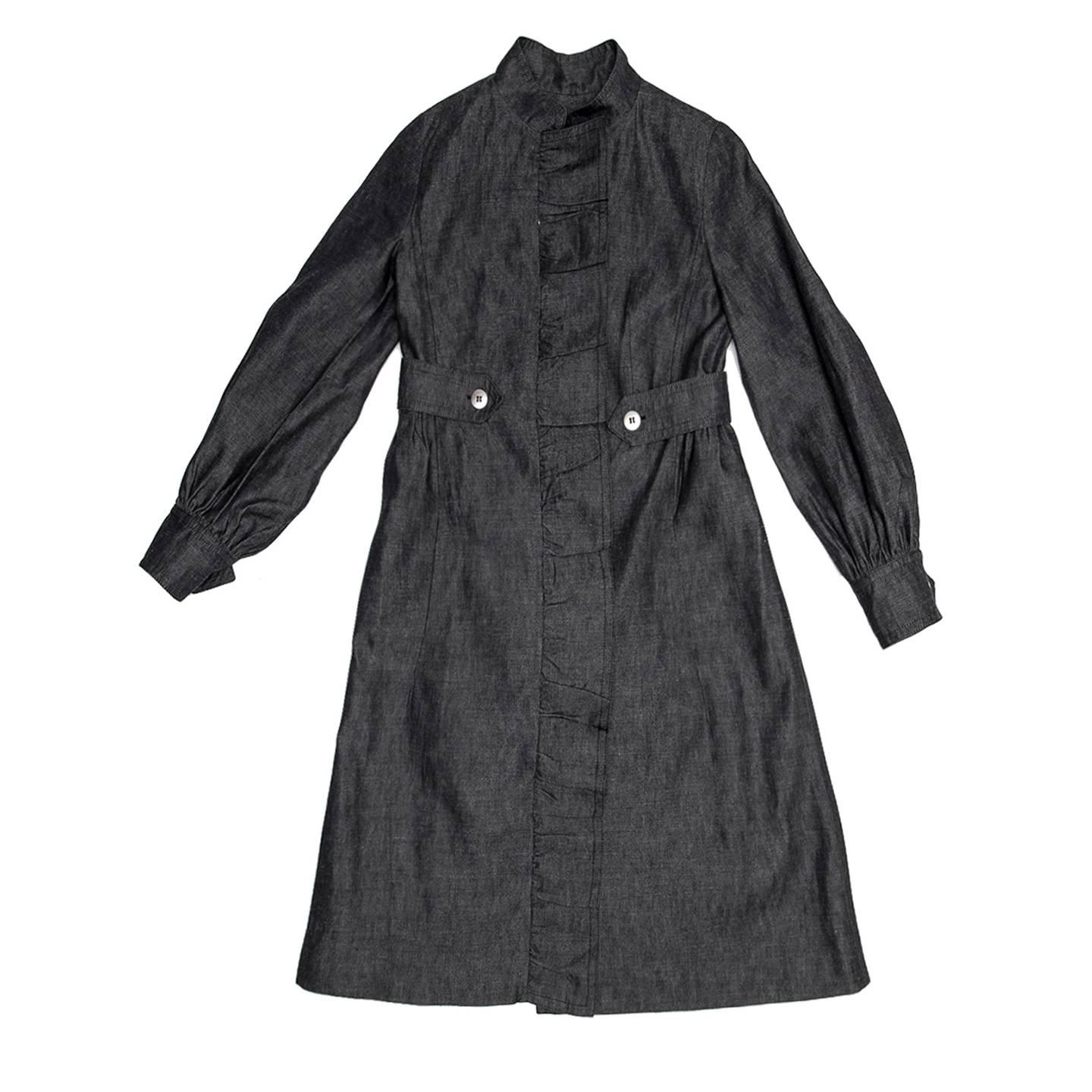 Cotton & ramie blend denim coat with an A-line skirt part gathered at side and back waistline. The length is below the knees, the collar is Nehru style and the waist is belted at sides only and fastened with silver metal buttons. The sleeves are