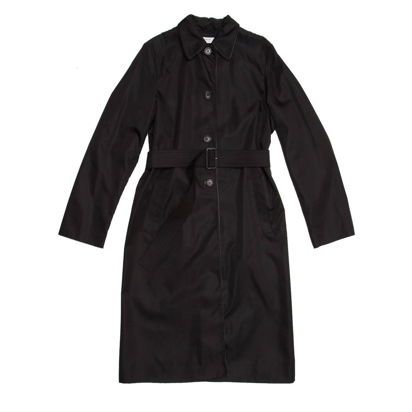 Black nylon knee length raincoat with leather piping around the peter pan collar and front opening. The front fastens with 4 buttons and a belt tighten at waist.

Size  44 Italian sizing

Condition  Excellent: worn a few times