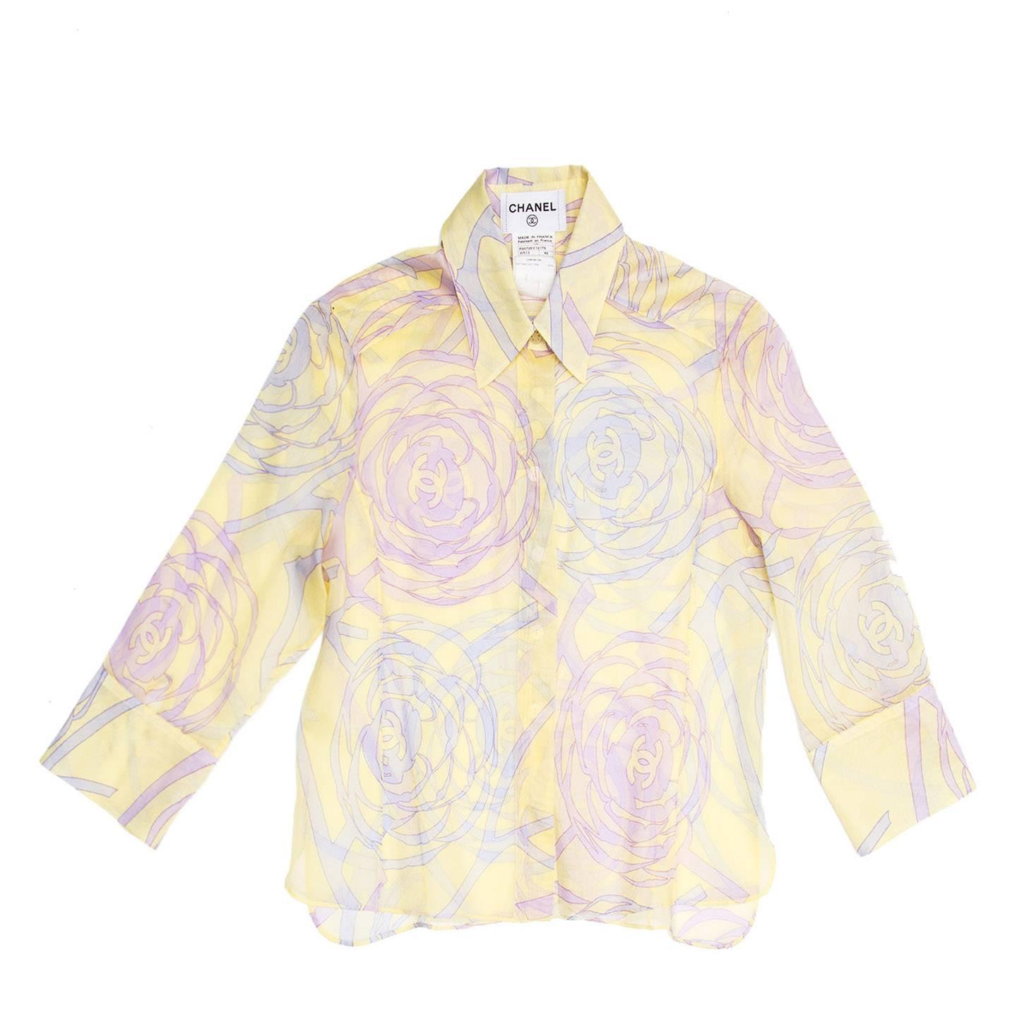 Yellow sheer cotton short shirt with purple and violet geometric floral print with Chanel logos. The sleeves are 3/4 length that fasten with beautiful mother-of-pearl floral cufflinks, the hem is straight with vents at sides. 
Made in France.

Size 