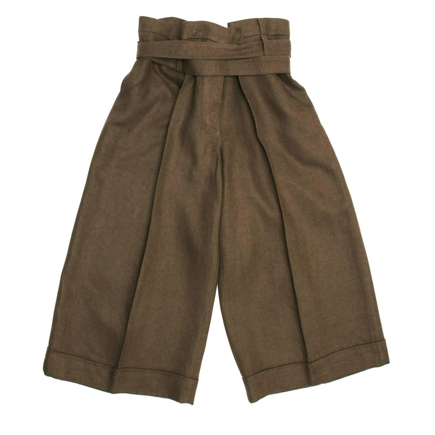 Paper bag color cropped style brown linen pants. The legs are very wide and the hem is finished with a classic turn-up. The back is enriched by two deep pleats fixed on the waist band and the back buckle that extends to form a wide belt. The linen