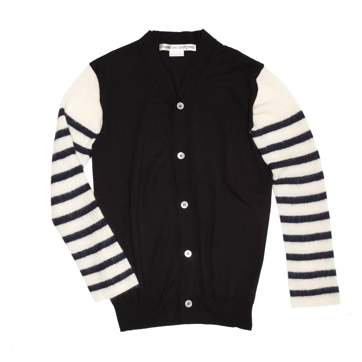 Black wool cardigan with ivory and navy blue striped sleeves which are attached to the body only at shoulder top, leaving the underarm open. The front fastens with mother of pearl round buttons leaving the V-neck very high. Japanese size Large, fits