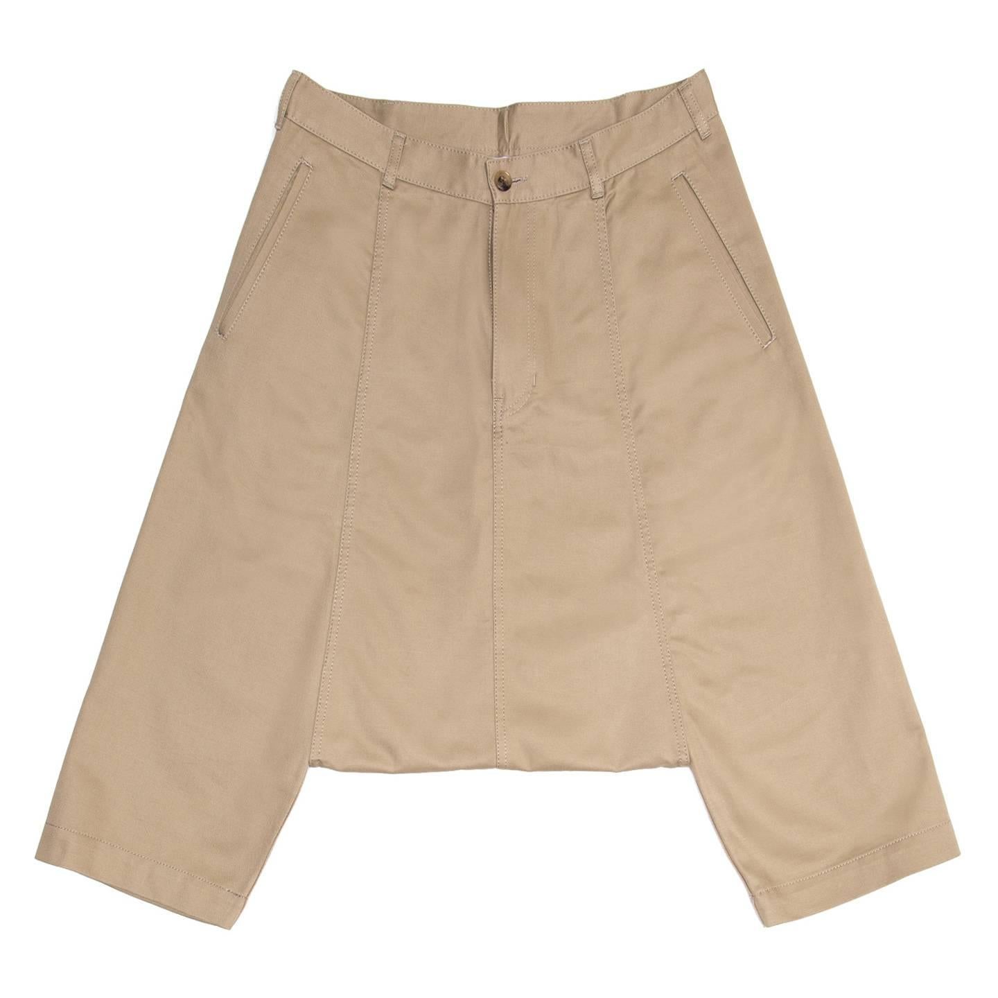 Khaki cotton harem style below knee pants with very low crotch to above knees. The front pockets are classic slit style while at the back the patch pockets are round and wide. All the seams are enriched by tone-on-tone top stitches as well as the