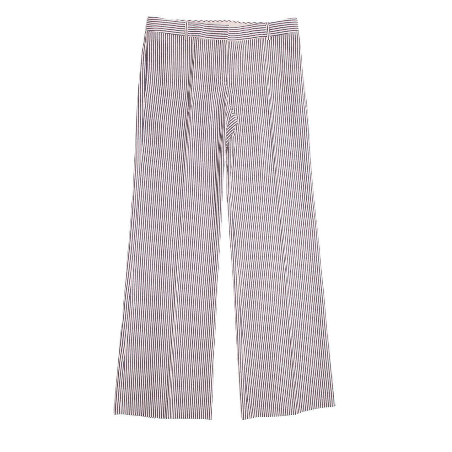 Blue & white seersucker striped palazzo pants with long and wide legs. The front is flat and the pockets are on the side seams, while the back is enriched by the horizontal stripes of the slash pockets and the back buckle style insert fastened with