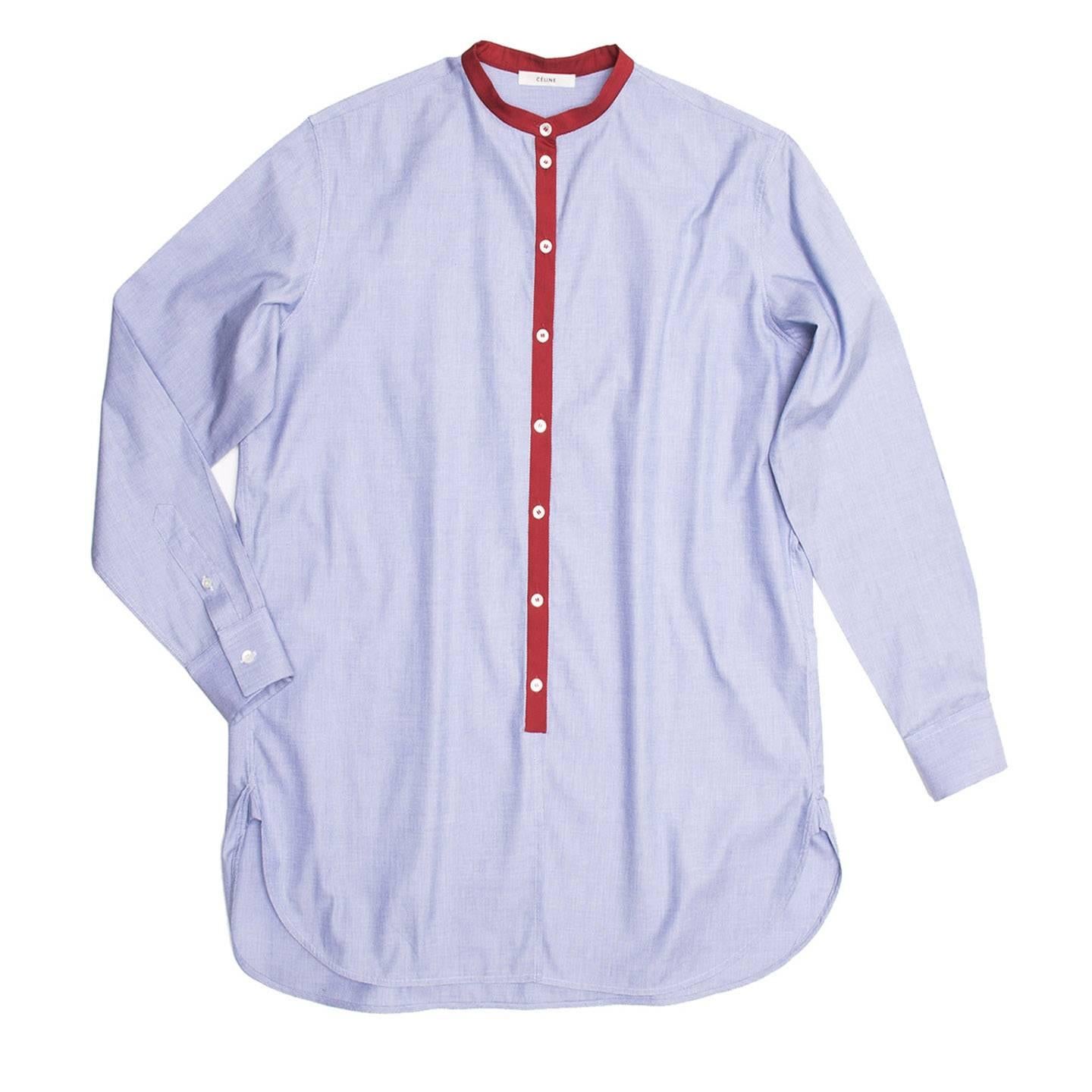 Oxford blue man style shirt with round shaped hem and detailed side vents. Red grosgrain Nehru collar and button placket. White buttons with contrast red thread on central front.

Size  38 French sizing

Condition  Excellent: worn a few times