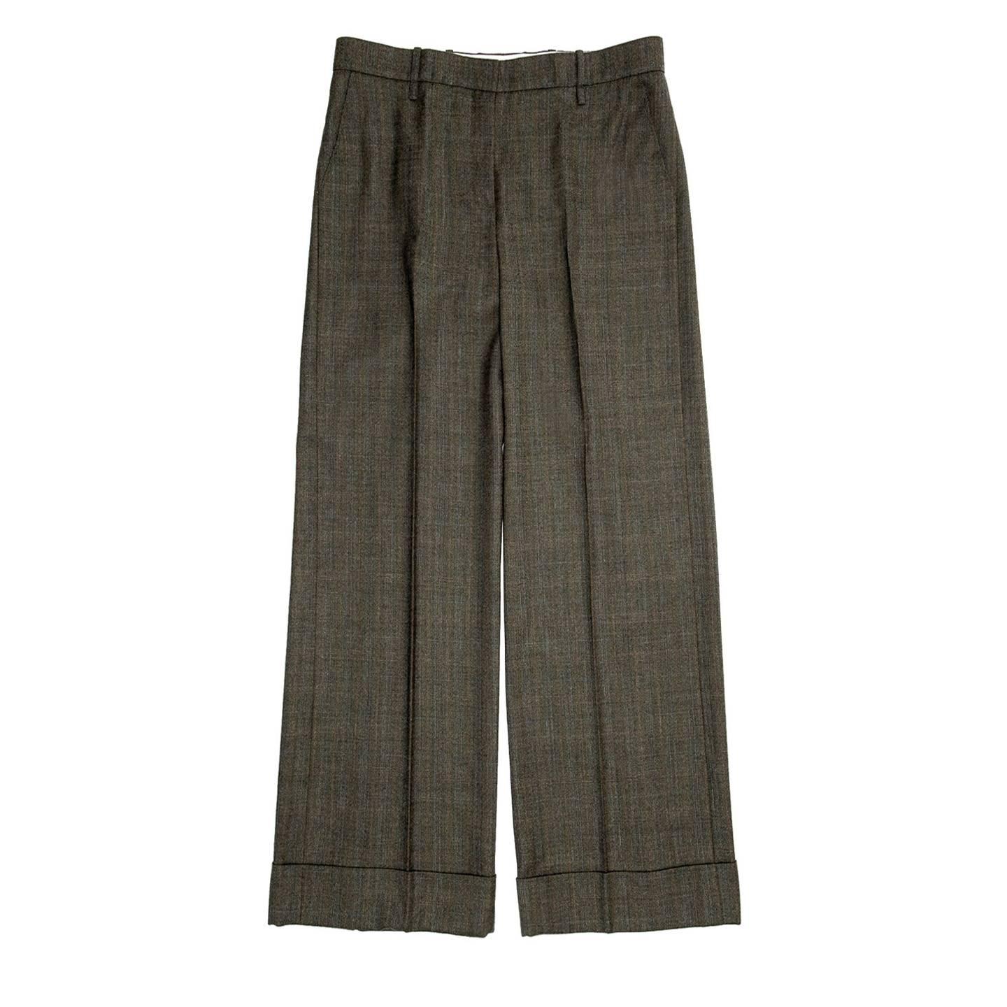 Musk green/blue/orange checked wool trousers with very wide legs and turn-ups at hem. The pants are pleated, the front is flat and a hidden hook fastens the waist band, which is enriched by detailed belt loops. Slash pockets sit at front while the