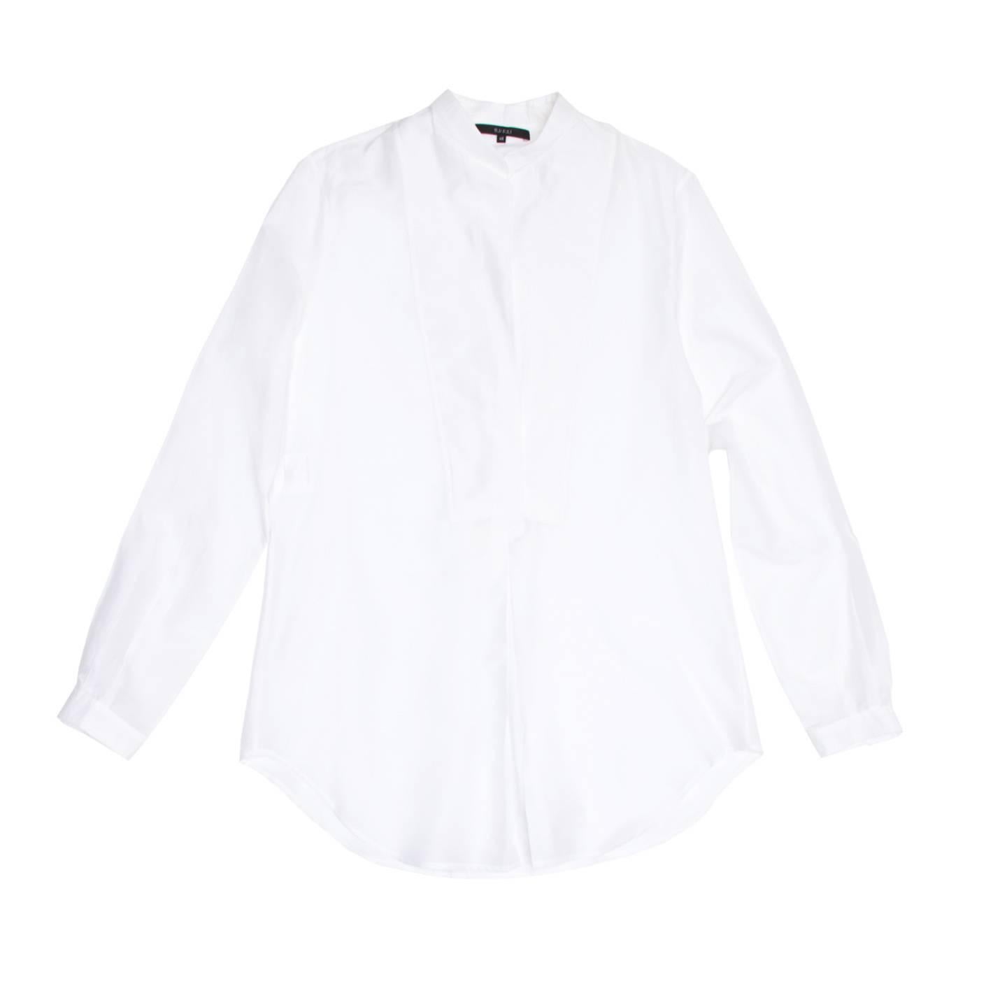 Beautiful light weight cotton and silk white shirt with Nehru collar. The fit is straight while an inverted pleat at center front and a box pleat at center back create movement and a little volume.The bib detail at front is composed of two identical