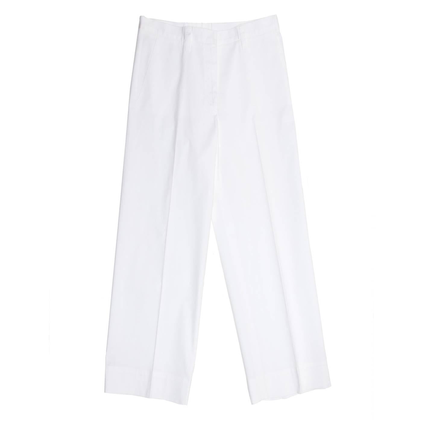 Classic white cotton and elastane trousers with a man's style and wide cropped legs. The pants are suit pleated, slash pockets at front and slit pockets at back. The waistband is thin, it fastens at front with a hidden hook and it's enriched by long