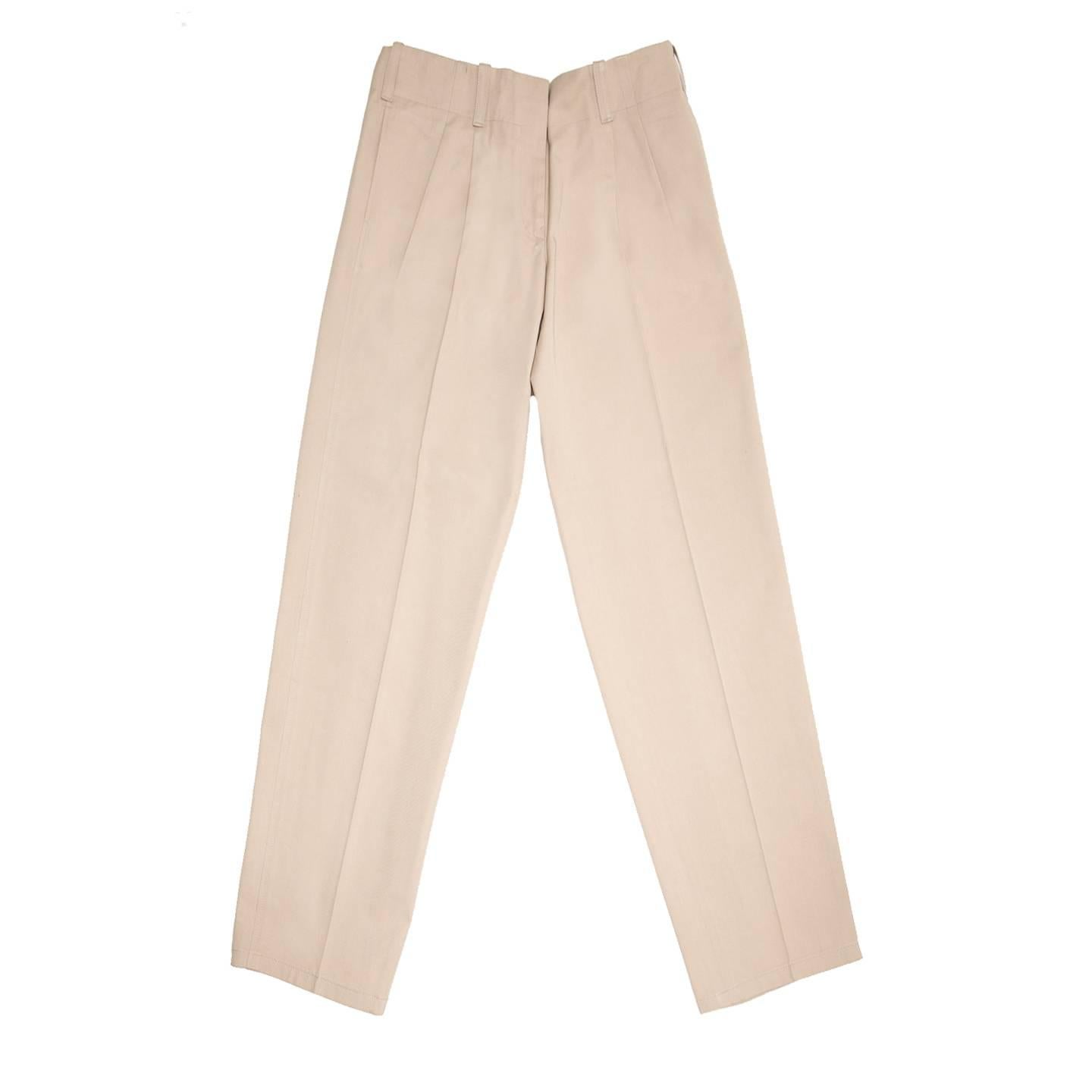 Khaki thick cotton trousers with a man's style. The pants are suit pleated, they have pleats at front waist that open from under the waistband line, slash pockets sit at side seams and slit pockets at back of which only one fastens with tone-on-tone