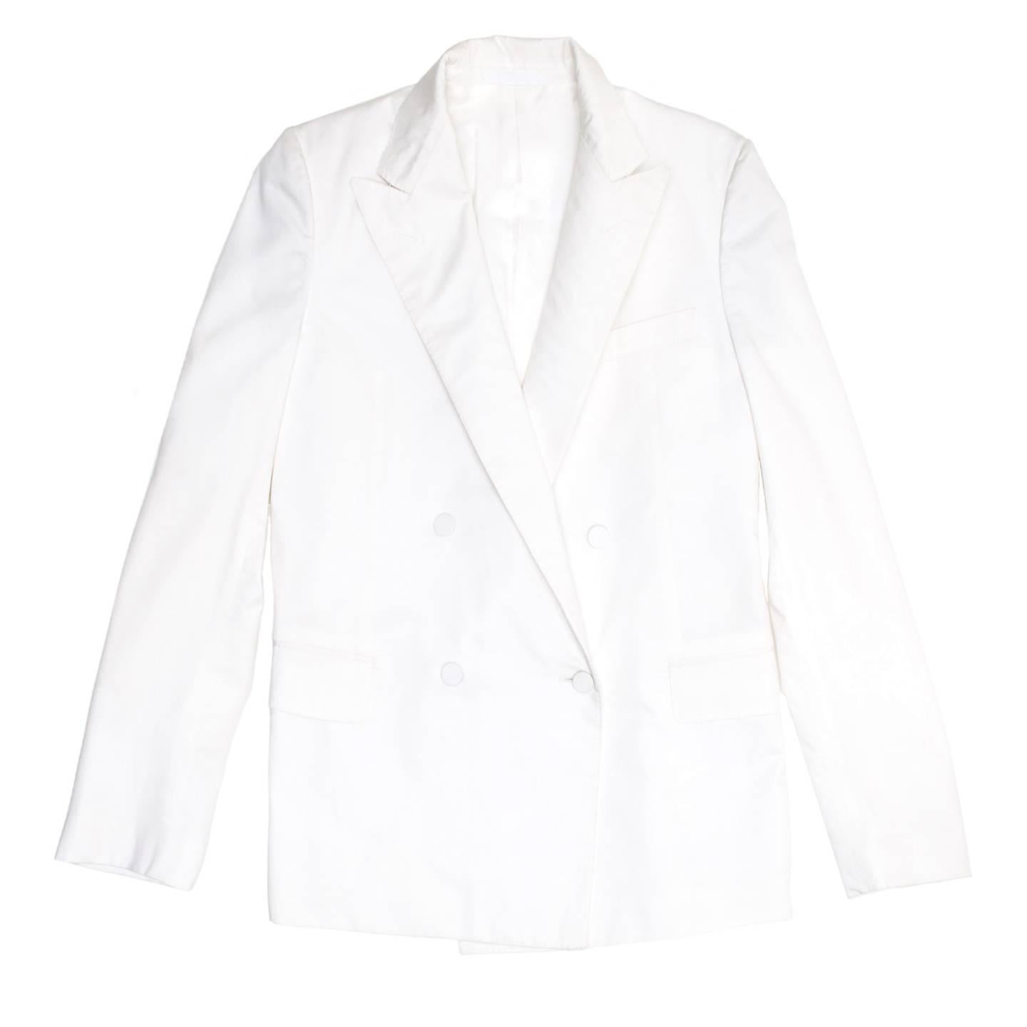 Elegant white cotton boxy blazer with peaked lapel and double breast closure. The front is enriched by self-fabric covered buttons, a breast pocket and two flap pockets at waist, while the back has two vents. Made in Italy.

Size  42 French