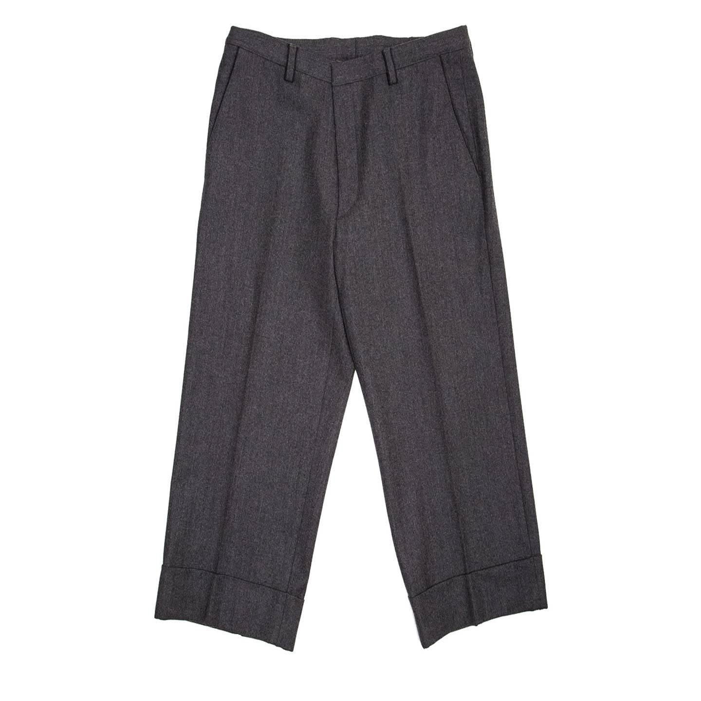 Grey wool suit pleated gaucho slack trousers with wide classic turn-ups. Belt loops, front slash pocket and back slit pockets are enriched by elegant dark grey profiles.

Size  44 French sizing

Condition Excellent: never worn