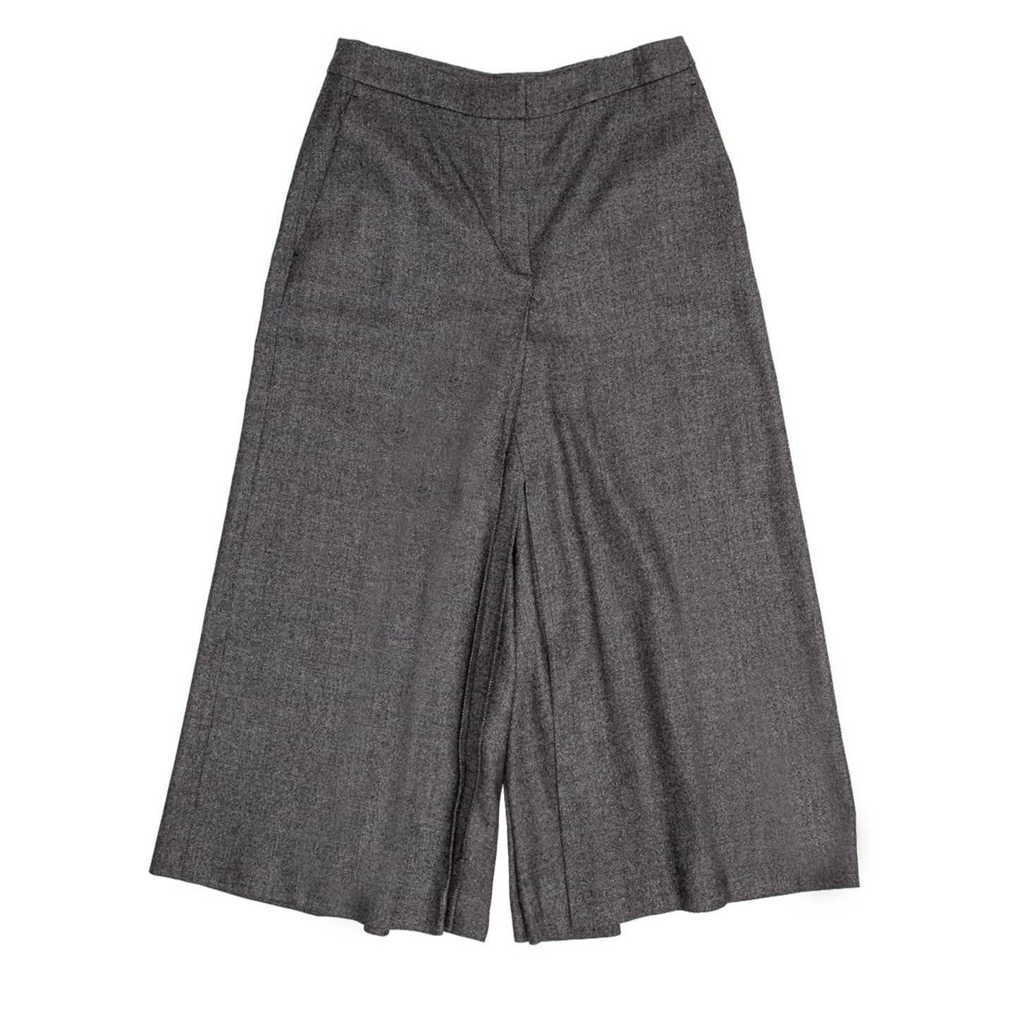 Grey virgin wool and cashmere blend tweed gaucho pants, high waisted and calf length. The inner legs are pleated and create the illusion of a skirt with a beautiful movement while walking. The front has minimal slash pockets and a back only one
