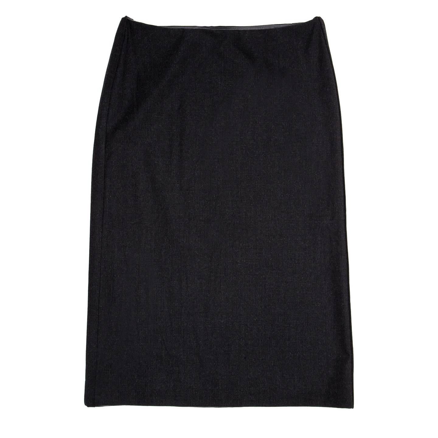 Elegant dark charcoal grey virgin wool skirt with a percentage of stretch that makes it more comfortable. From waist to hem a combination of two fixed inverted and box pleats at side seams enrich the straight cut of the skirt. The waistline is low