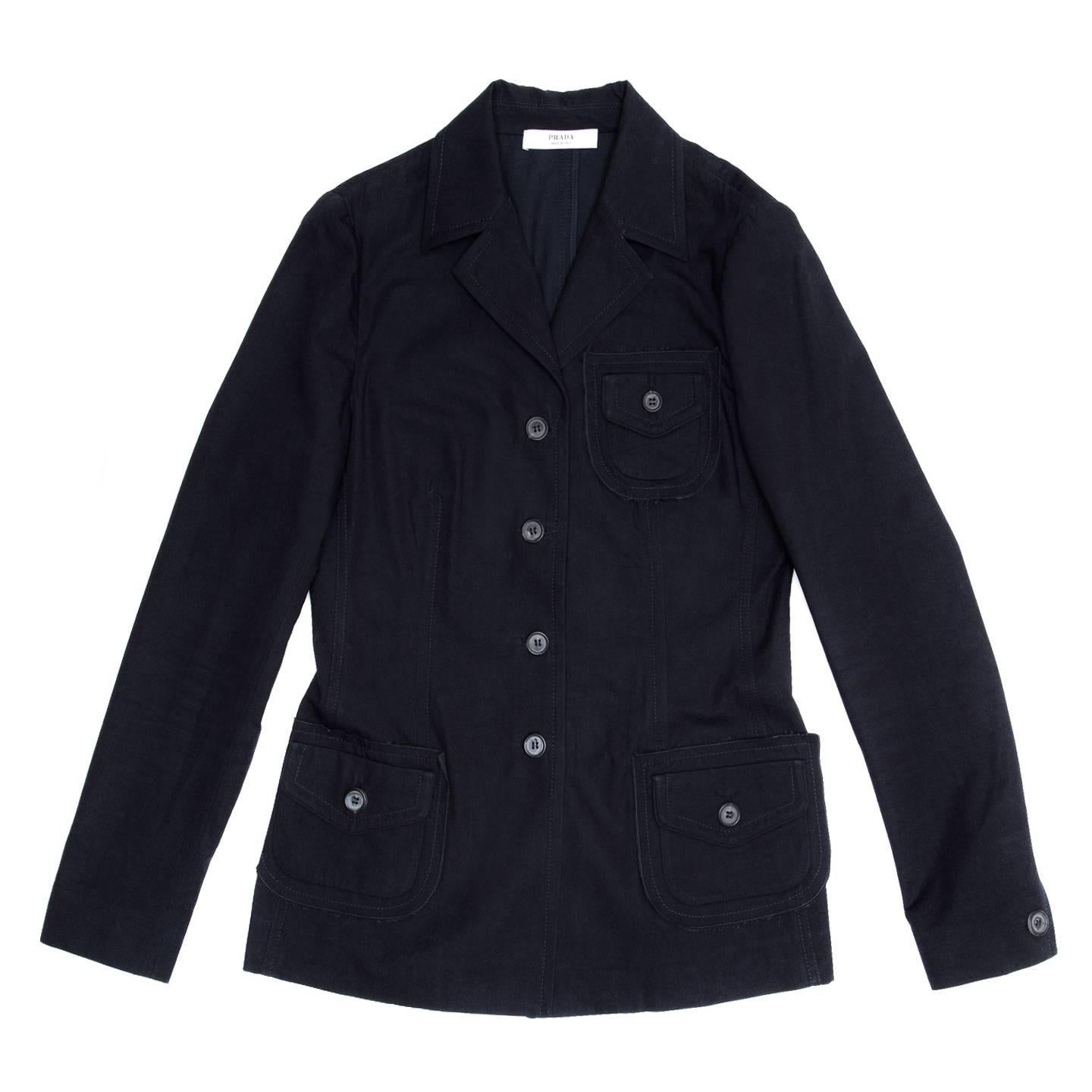 Prada navy cotton casual jacket with 4 buttons opening and small lapel. The front is decorated with three patch pockets with raw edges, flap and button. The fit is tight and hip length and all the seams are enriched by tone-on-tone top stitches.